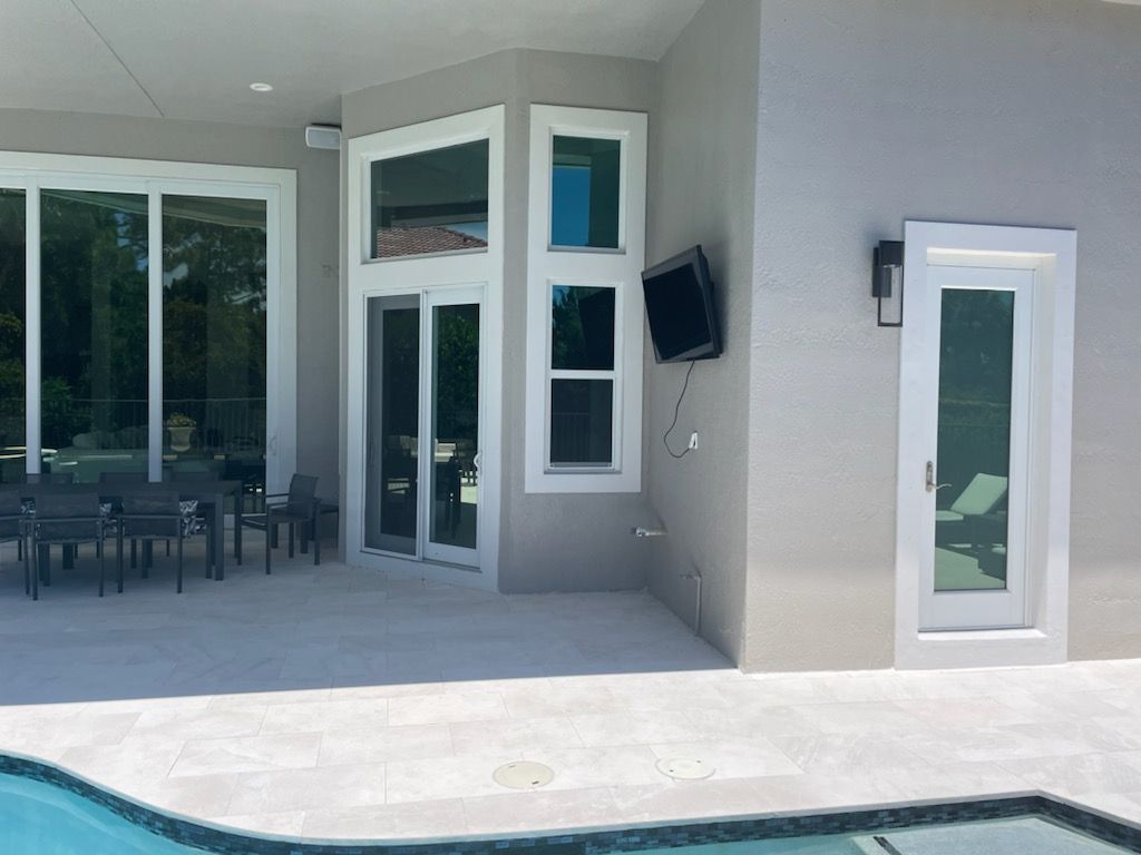 Patio with sliding glass doors, a small pool, and outdoor dining area beside a modern house