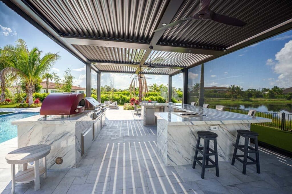Open-air patio with striped pergola, bar stools, white seating, and a poolside lagoon view