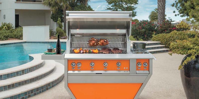 Orange outdoor barbecue grill beside a pool in a backyard patio area