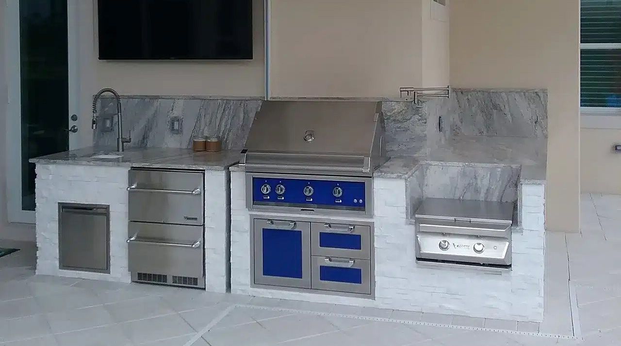 Modern toy kitchen set with silver cabinets, blue oven, and sink against a wall.