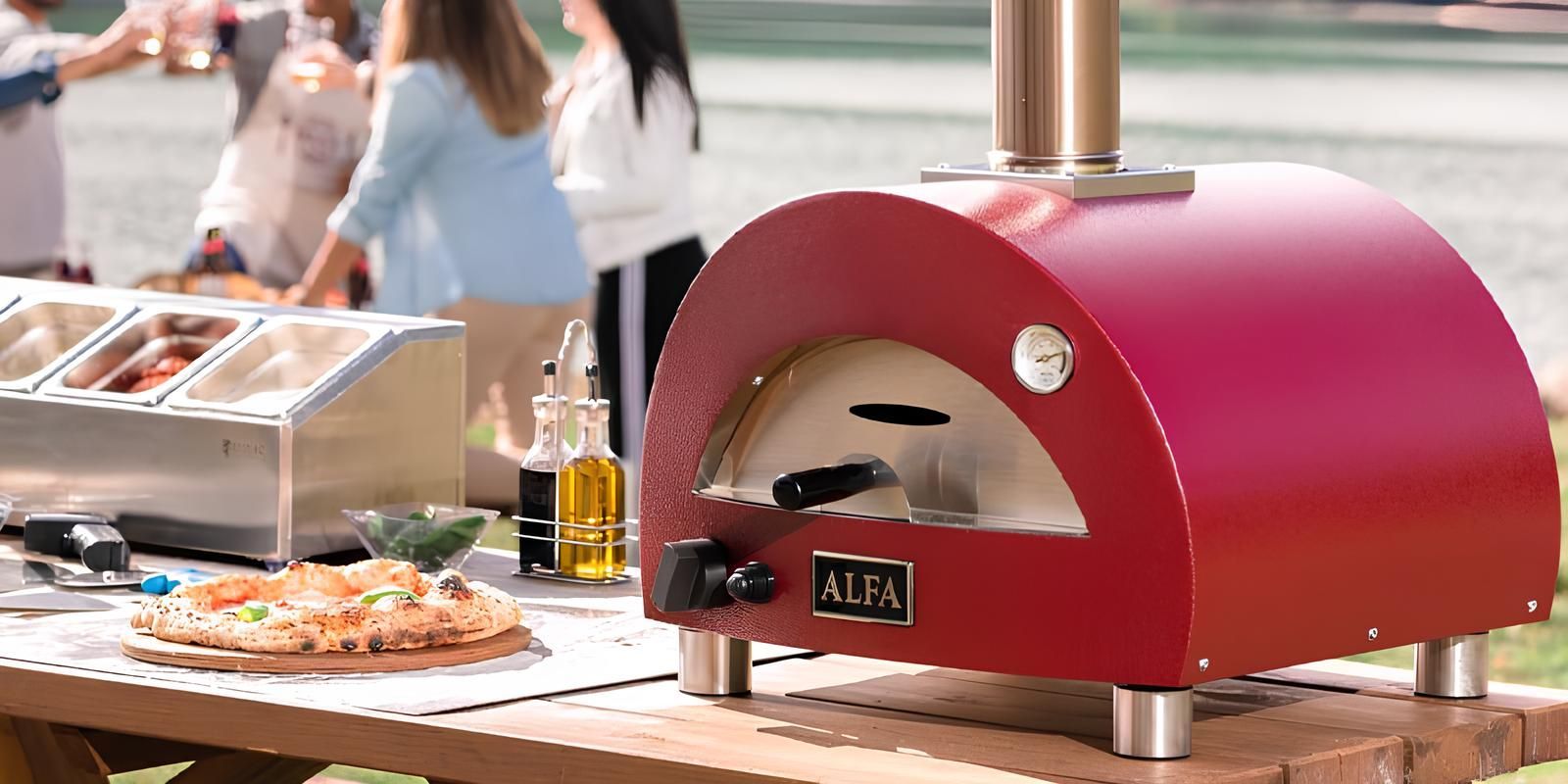 Outdoor food stall with a red dome pizza oven and a pizza on a tray nearby