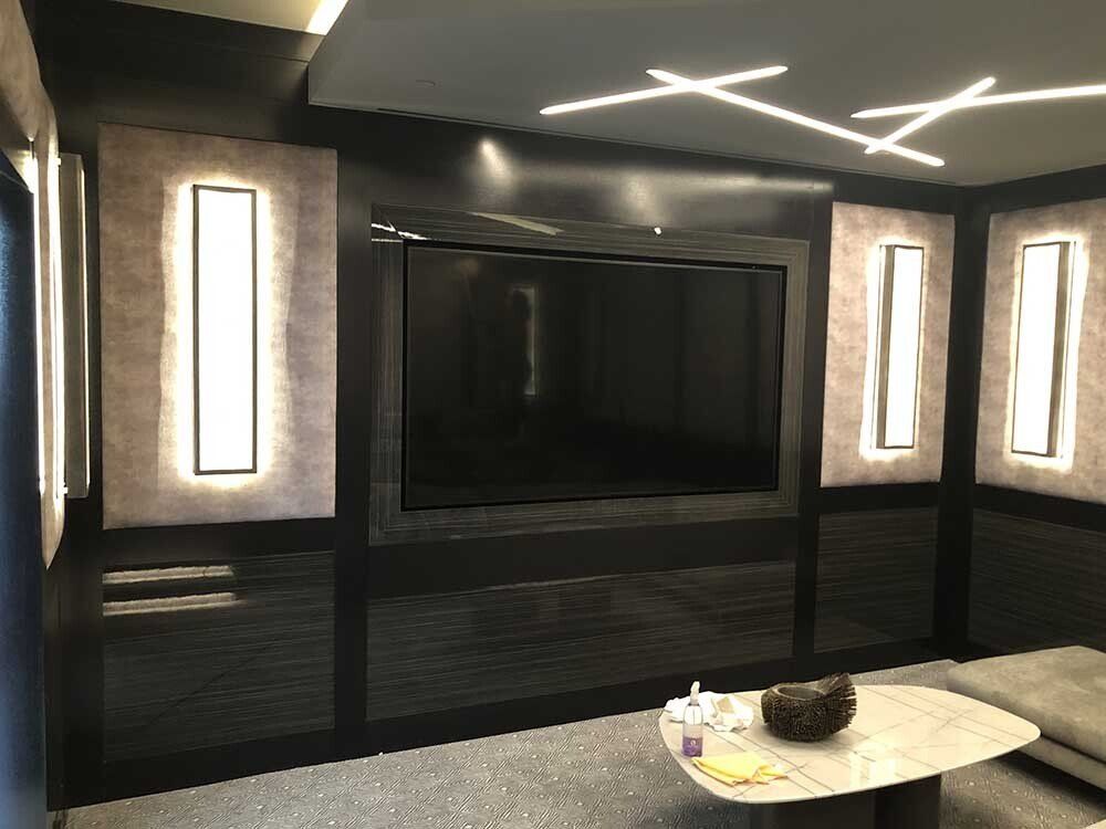 Home theater with large screen, built-in lights, and modern décor.