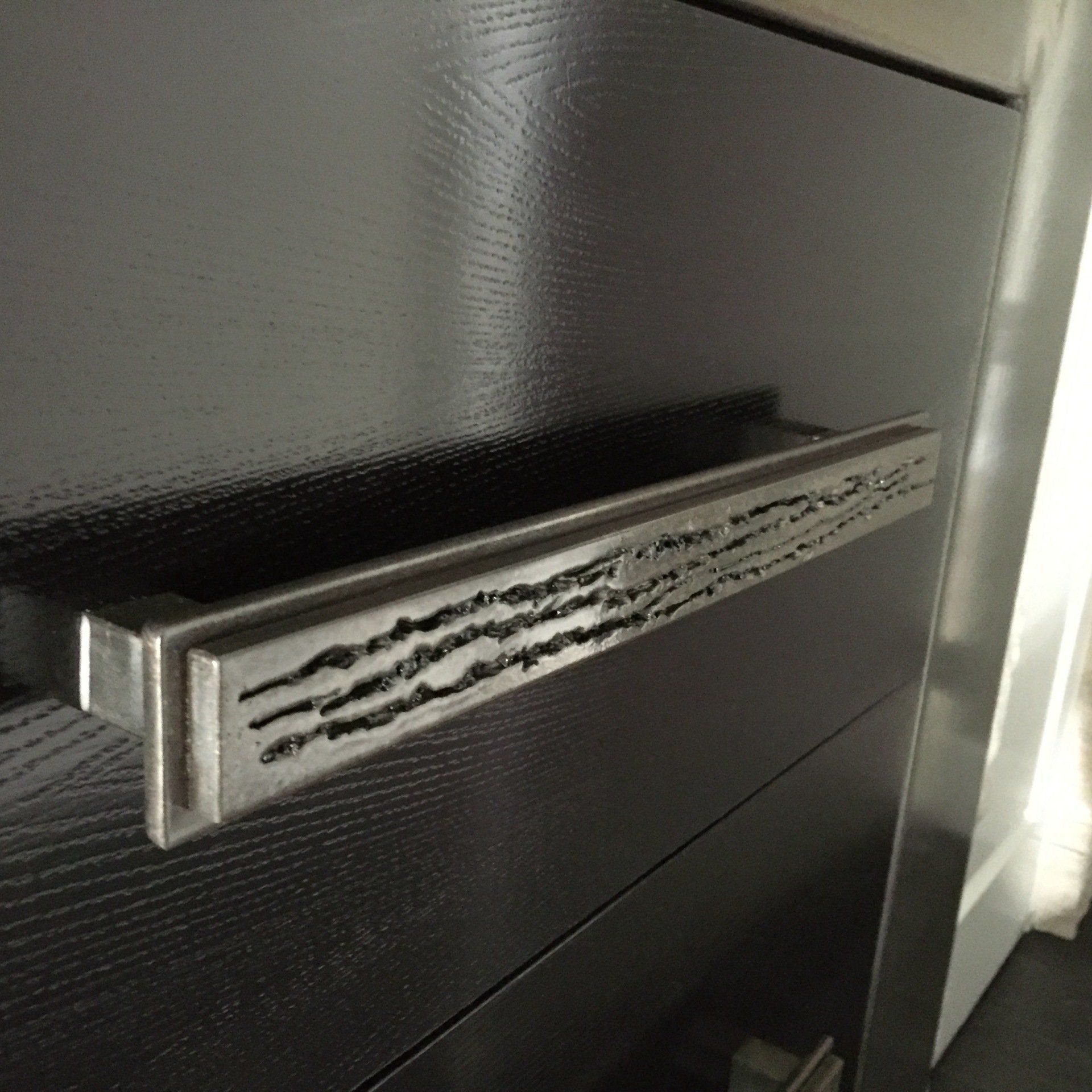 Black dresser drawer with a textured metal handle.