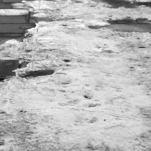 Melting snow and ice on brick walkway.