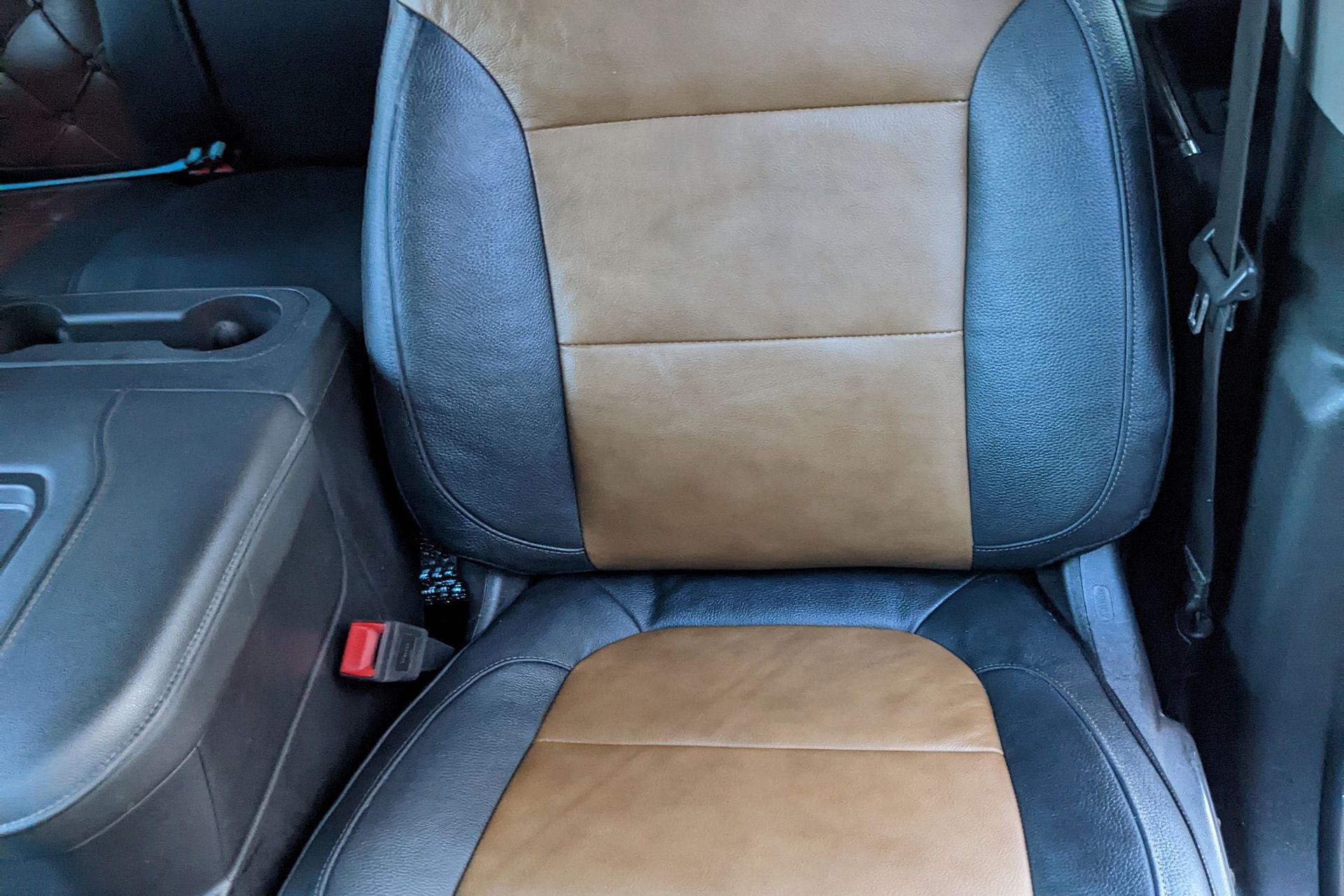 Interior of a motorhome with brown and beige seating, a table, and driver's area visible.