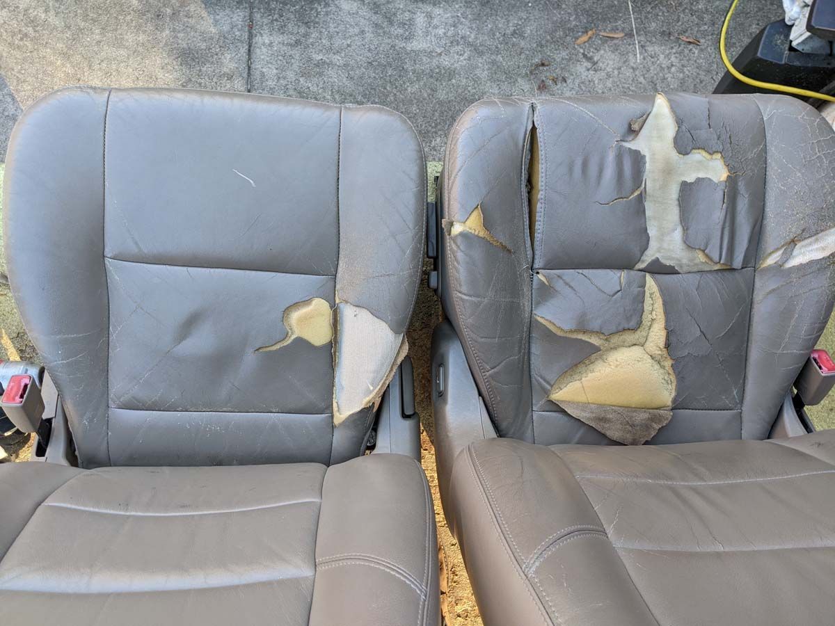 Two car seats, one with significant tears in the gray upholstery, the other less damaged.