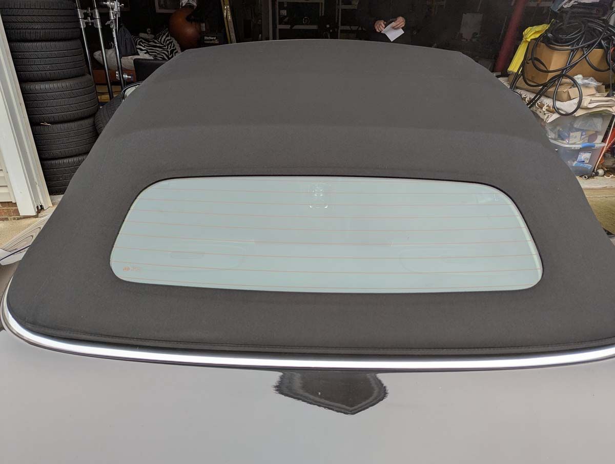 Black convertible top with a clear rear window on a car.