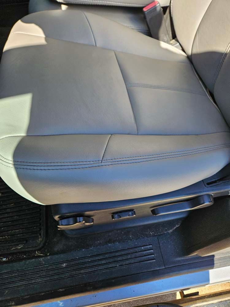 Tan leather car seat with power controls.
