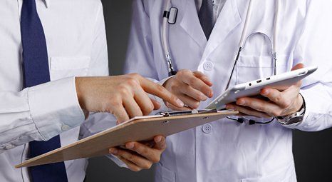 Doctor looking at a patient's form while holding a tablet