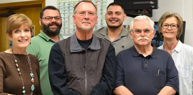 A group of people are posing for a picture in a room.