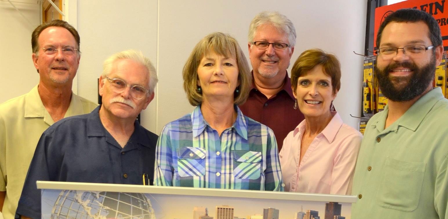 A group of people standing next to each other holding a sign.