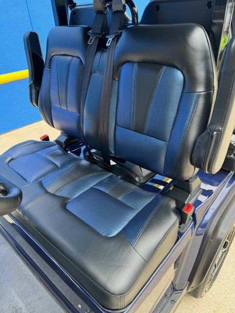 The seats of a golf cart are black and blue.