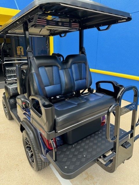 A black and blue golf cart is parked in front of a blue building