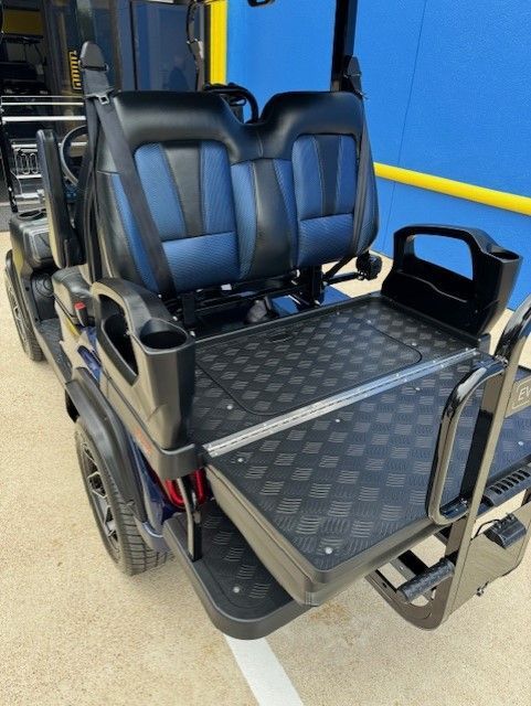 A black and blue golf cart is parked in a parking lot.