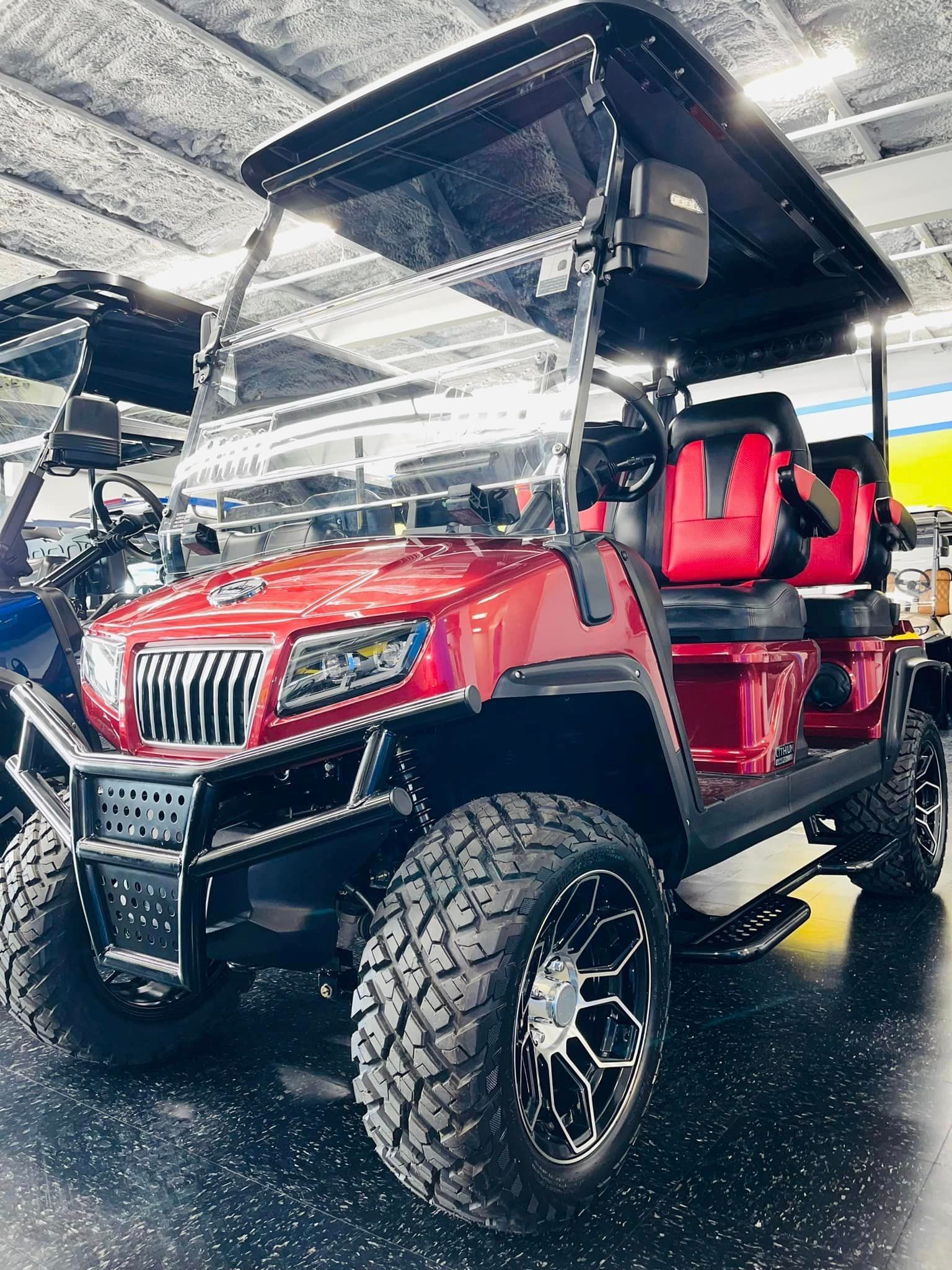 A red golf cart is parked in a garage.
