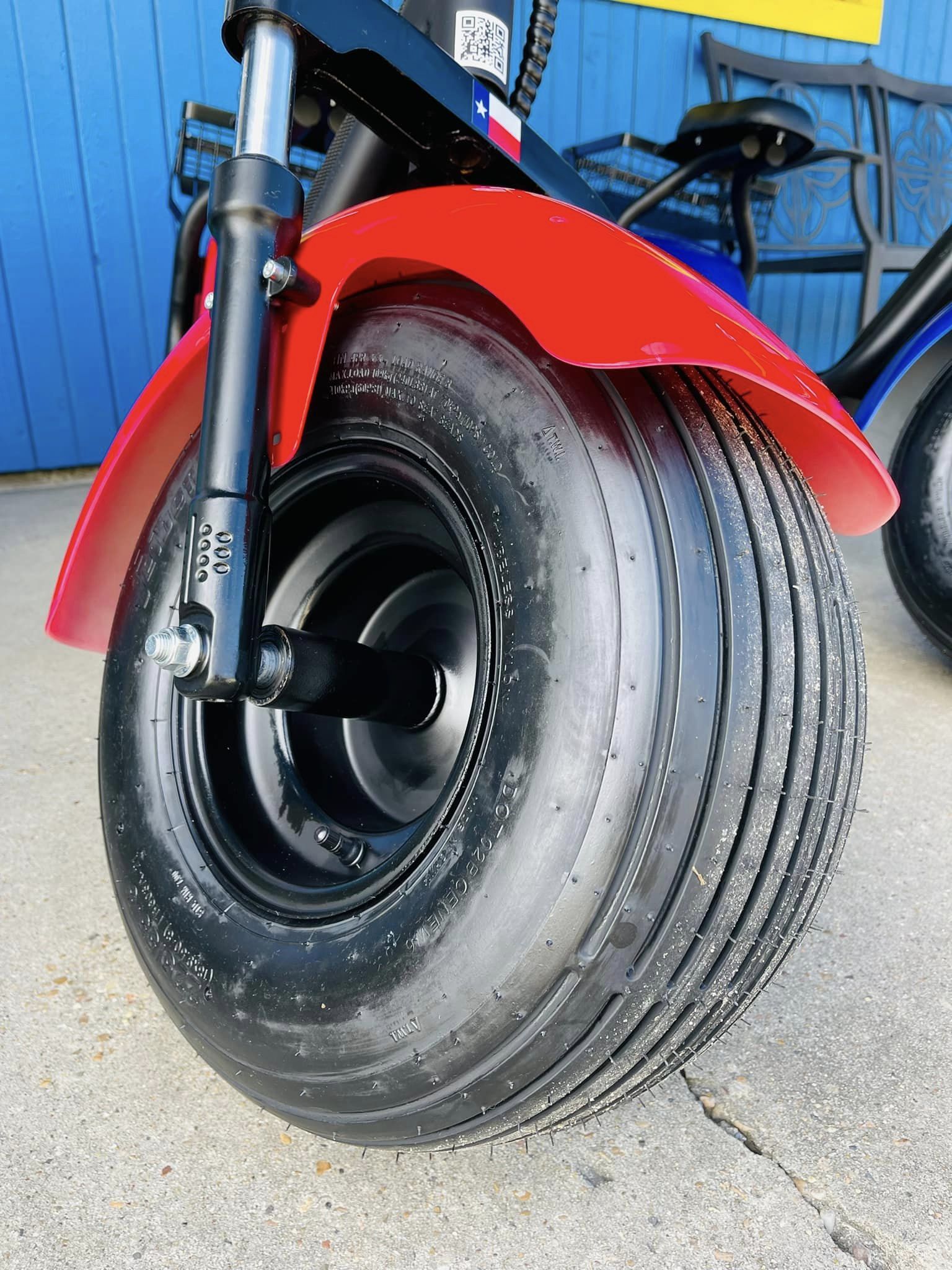 A close up of a motorcycle wheel with a red fender