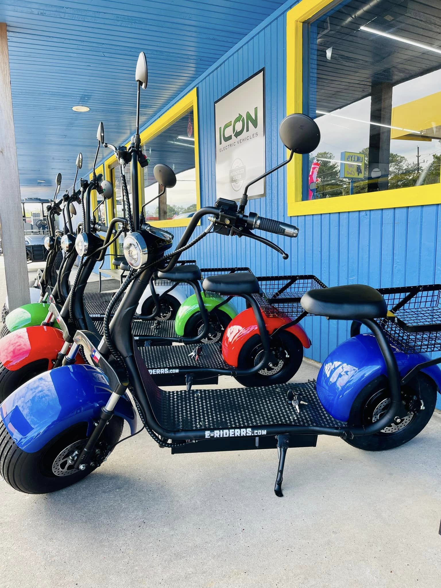 A row of scooters are parked in front of a building that says icon