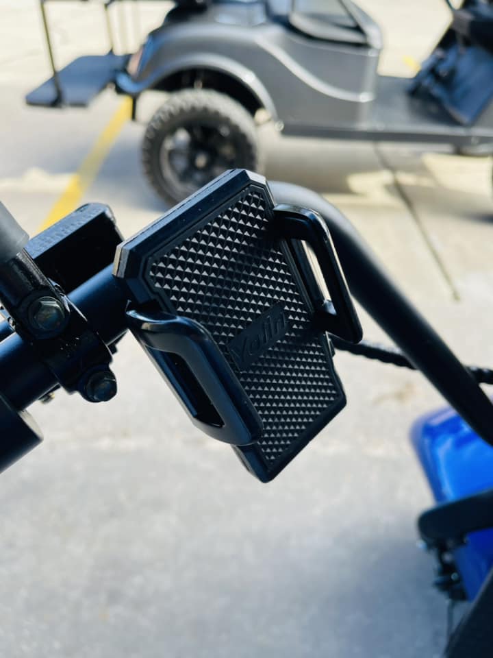 A cell phone holder is attached to the handlebars of a golf cart.