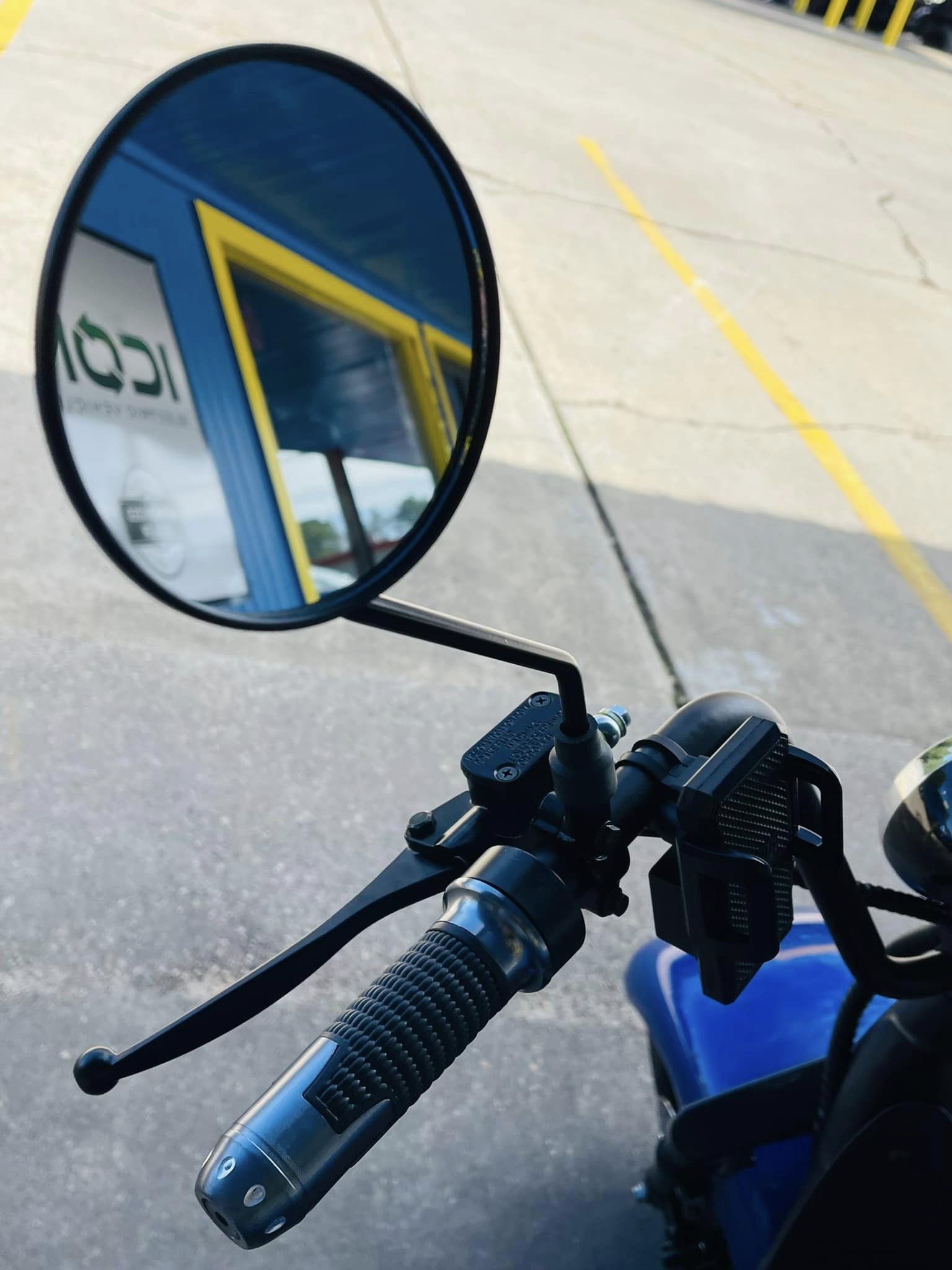 A motorcycle is parked in a parking lot with a sign that says icon