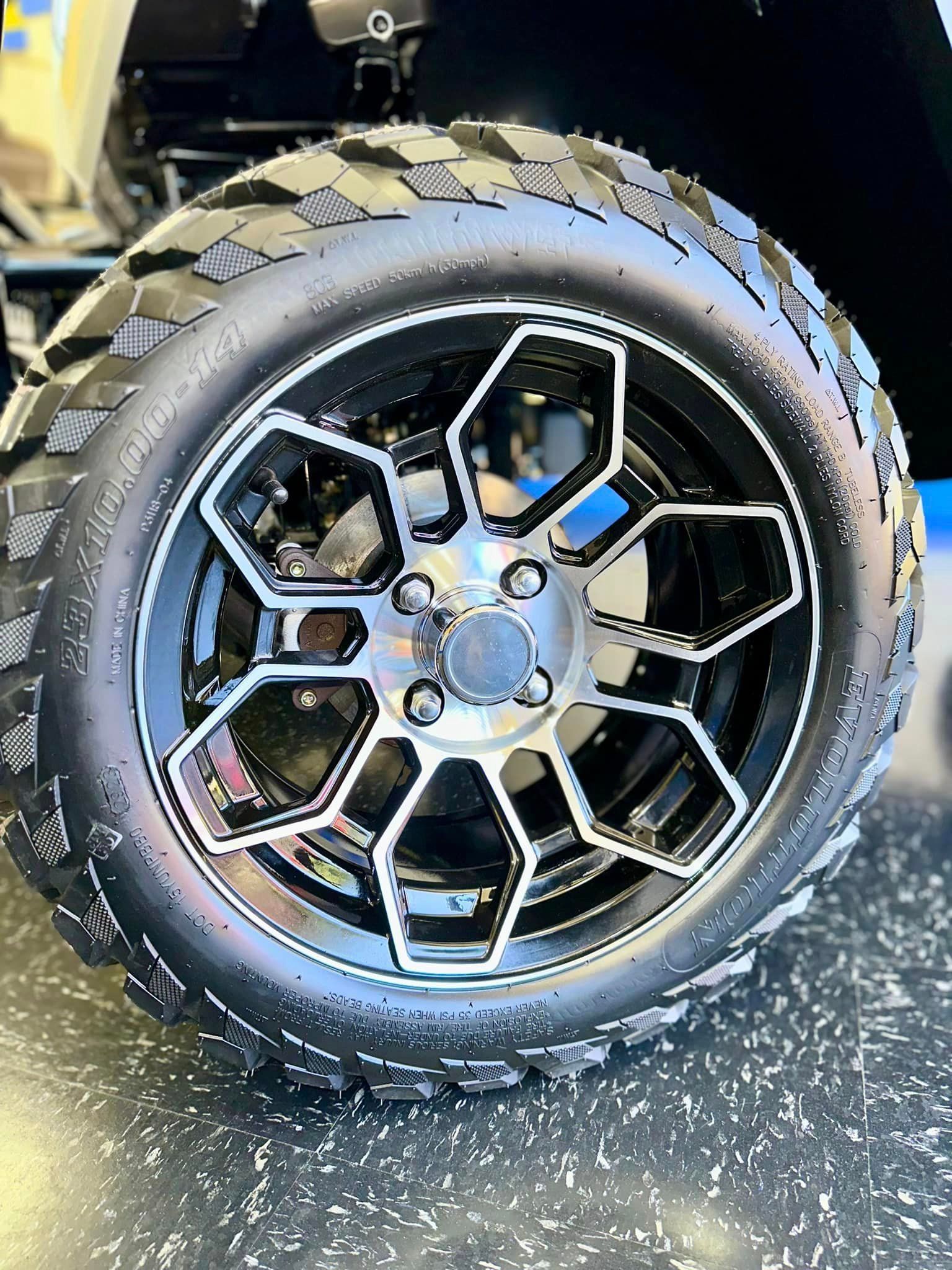 A close up of a golf cart wheel and tire.