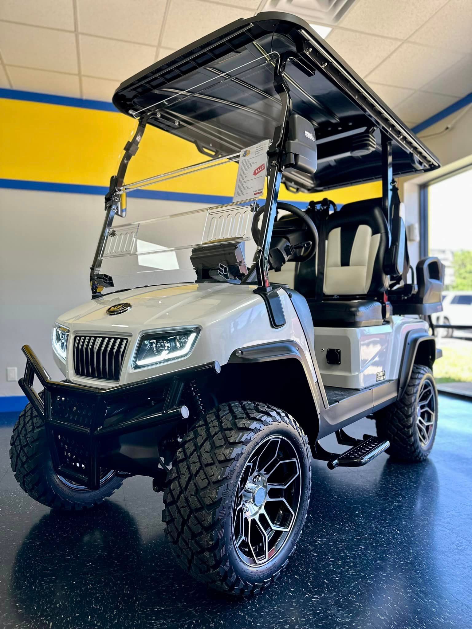 A white golf cart is parked in a garage.