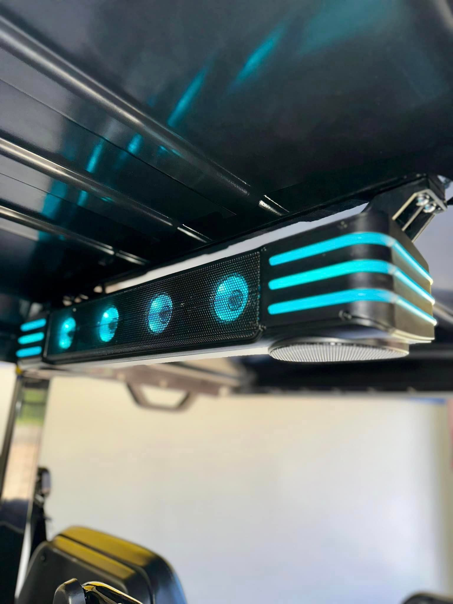 A golf cart with a ceiling fan and speakers on it.