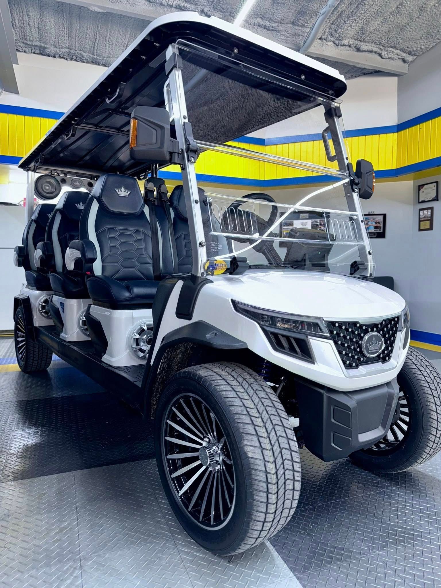 A white golf cart is parked in a garage.