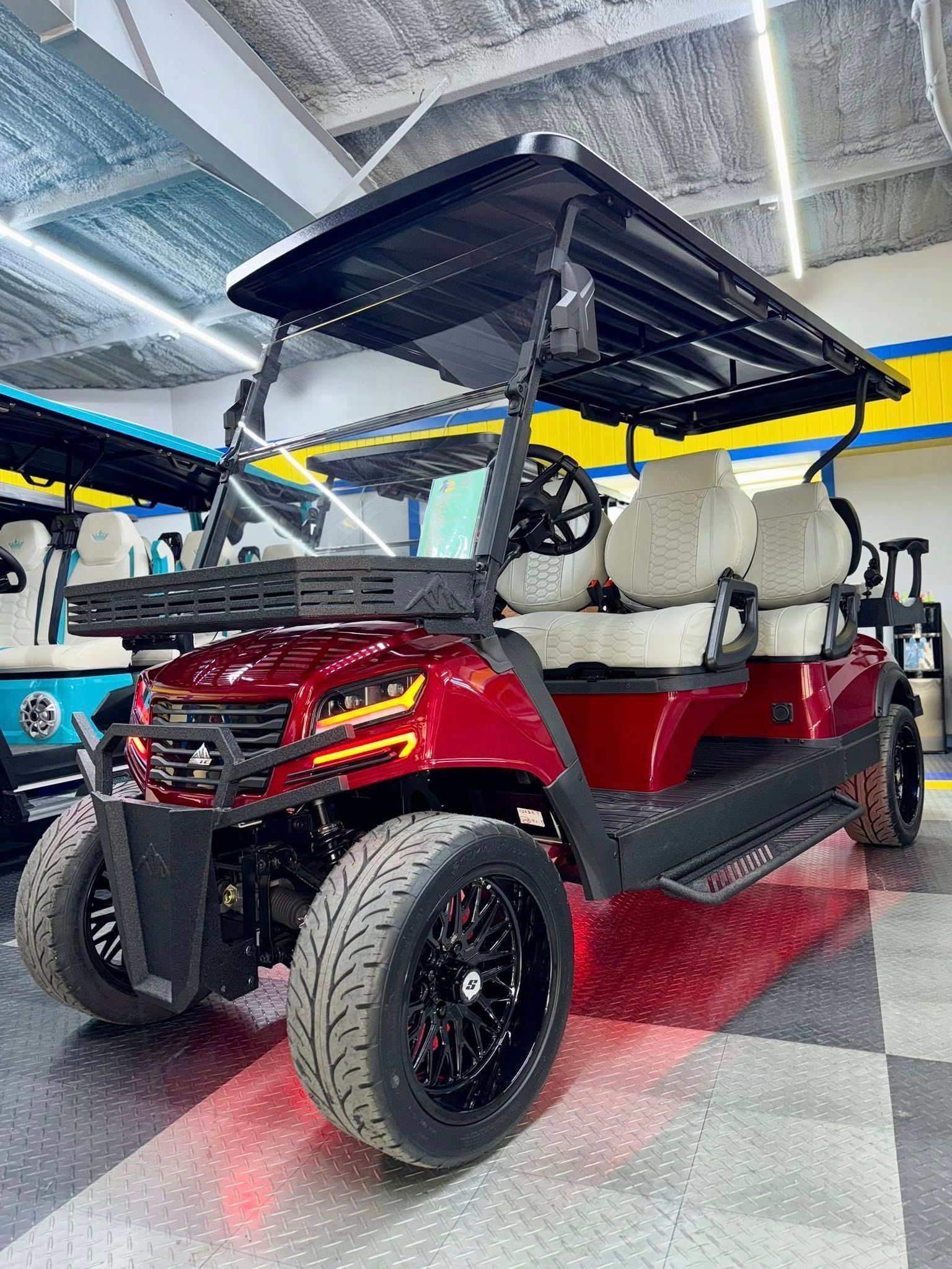 Red golf cart with black accents, large tires, and a sunshade.