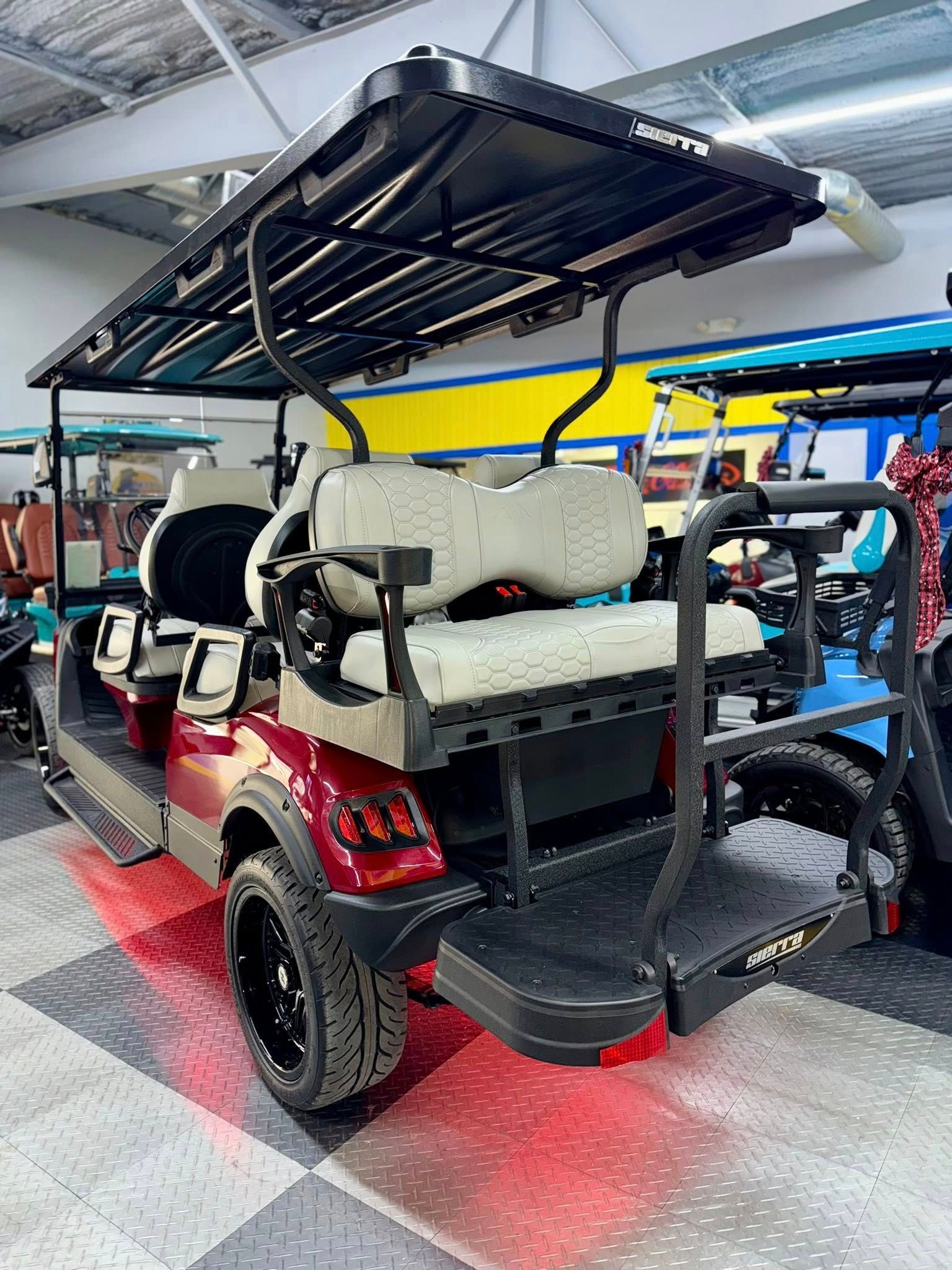 Red golf cart with black roof, seats, and tires, on a checkered floor.