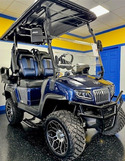A blue golf cart is parked in a garage.