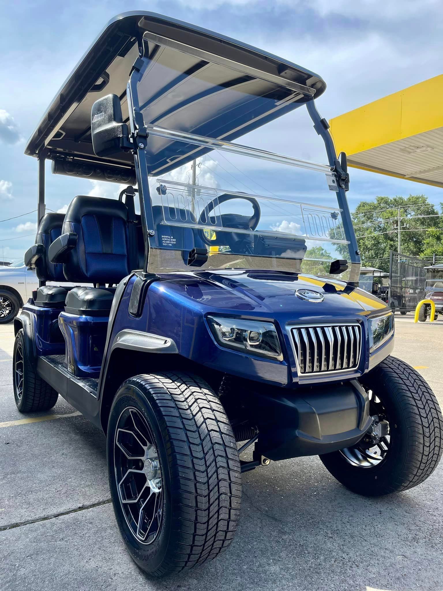 A blue golf cart is parked in front of a gas station.