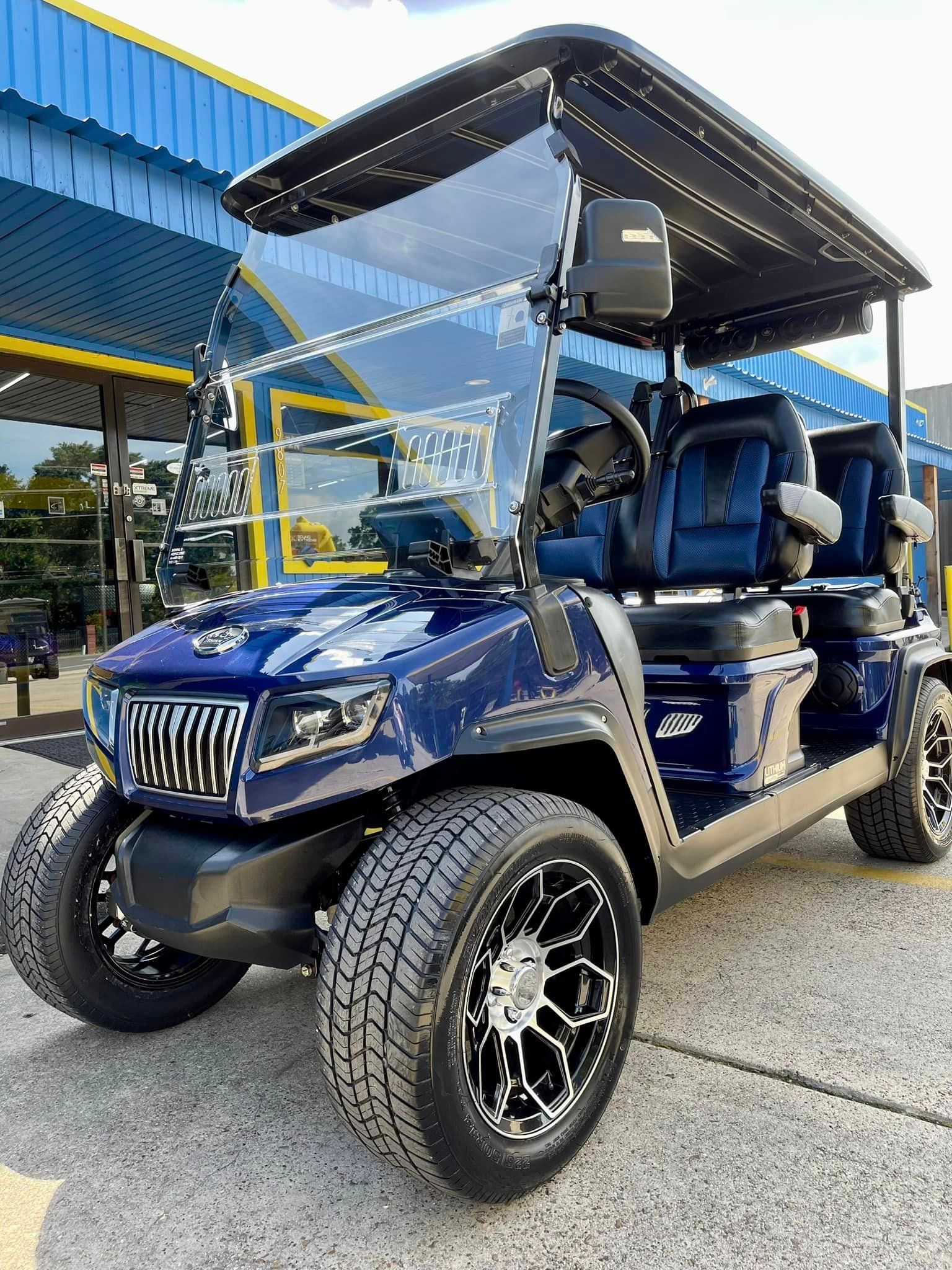 A blue golf cart is parked in front of a building.