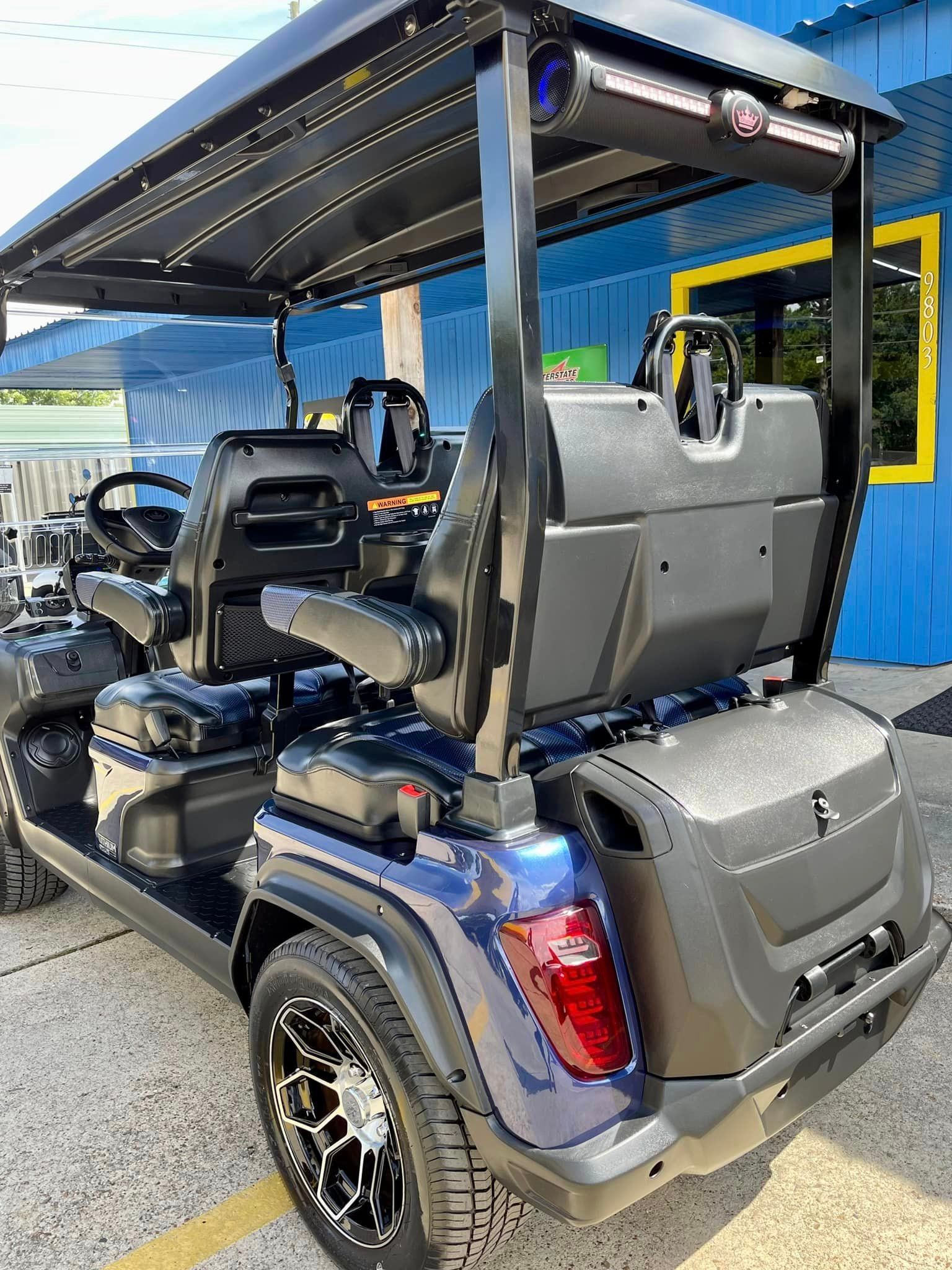 A golf cart is parked in front of a blue building.