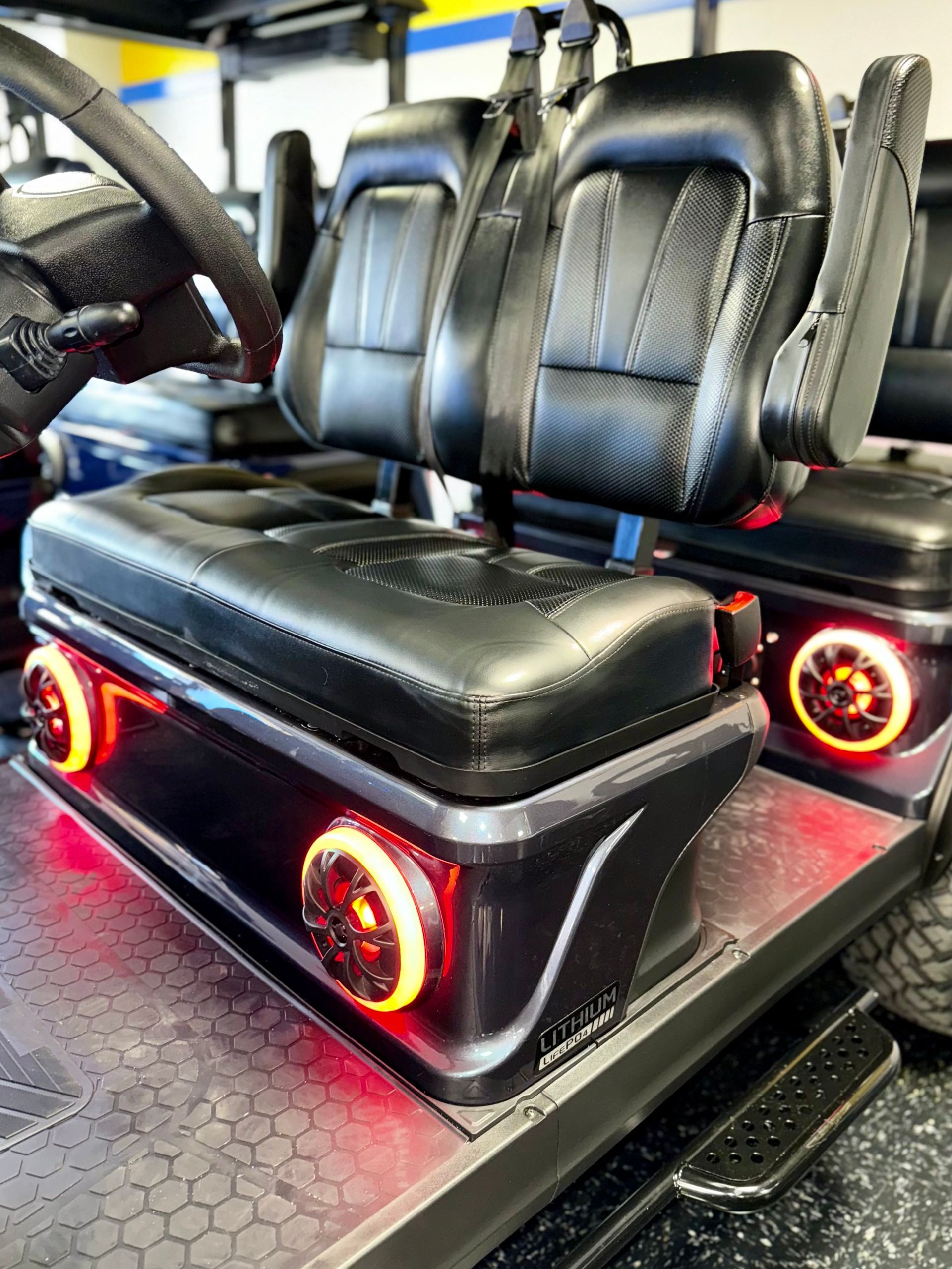 The back seat of a golf cart with lights on it.