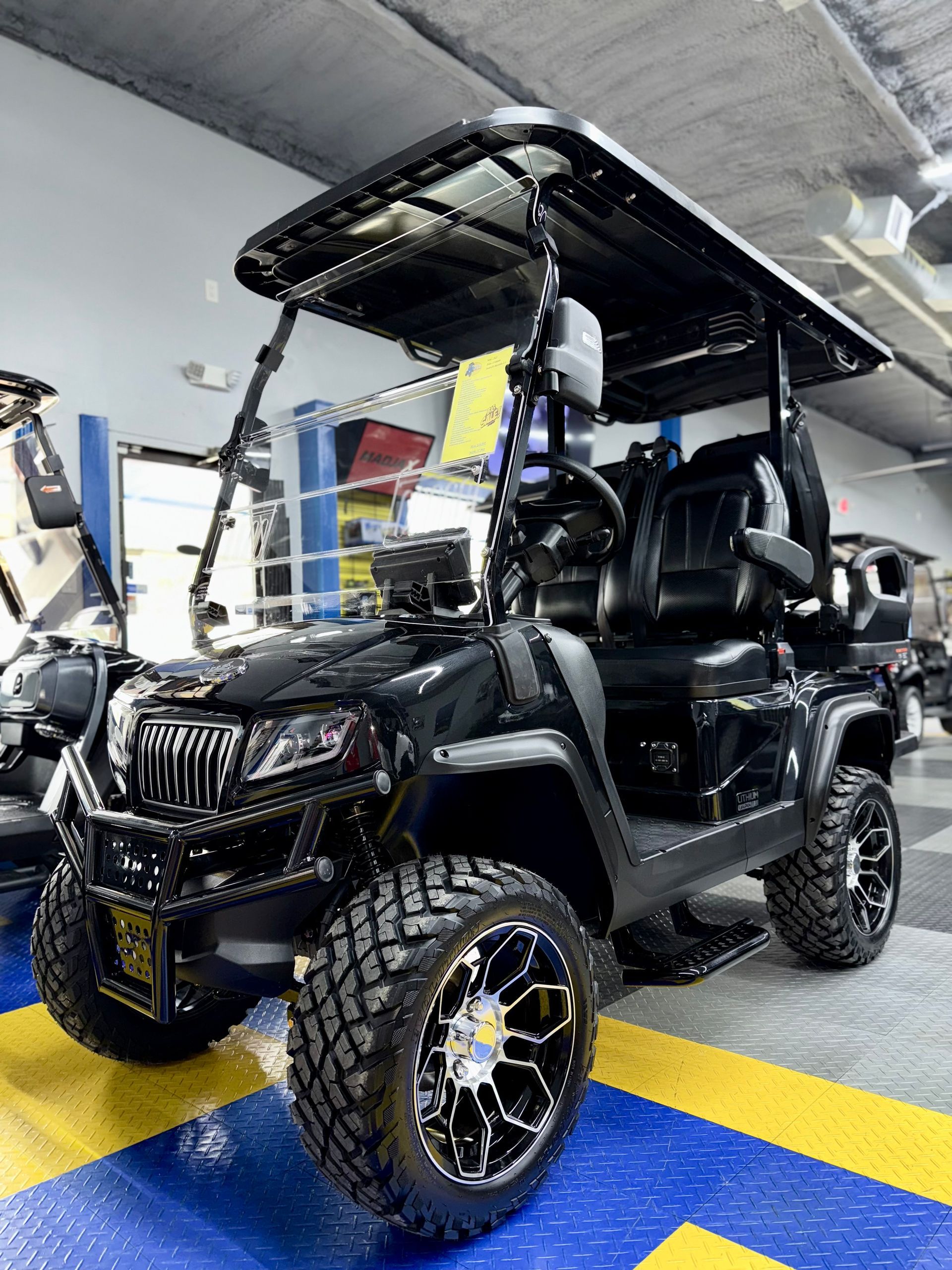 A black golf cart is parked in a garage.