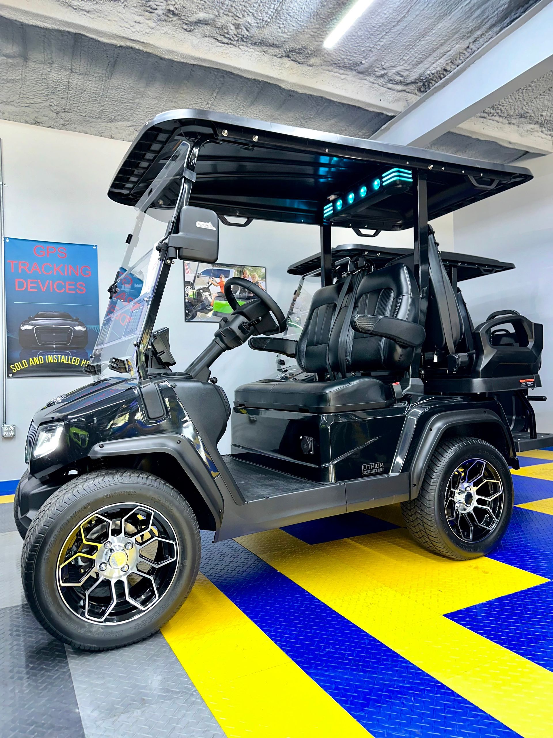 A black golf cart is parked in a garage.