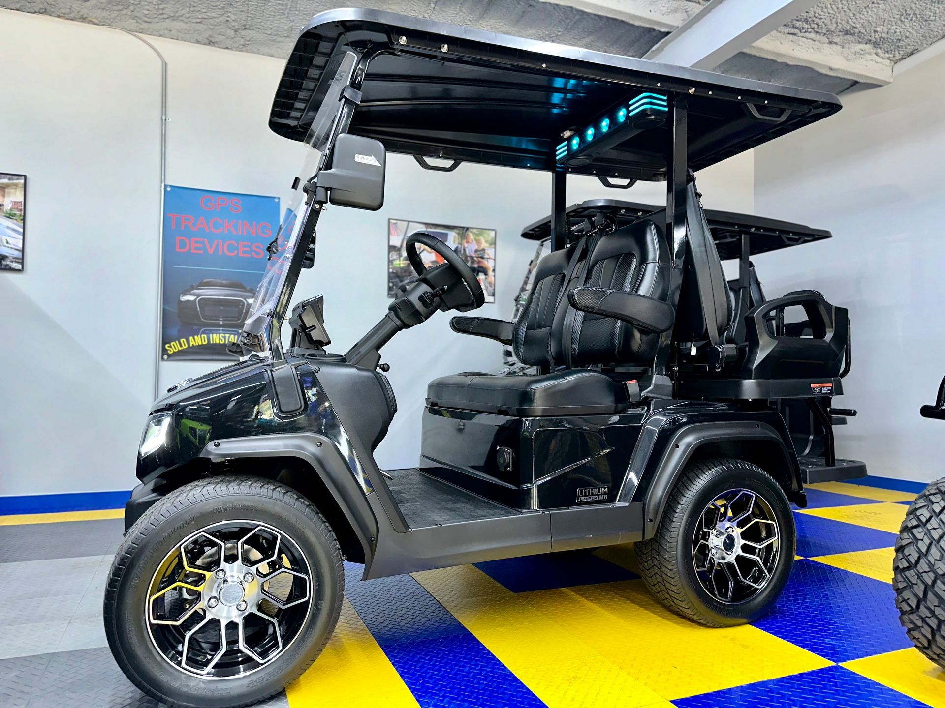 A black golf cart is parked in a garage.