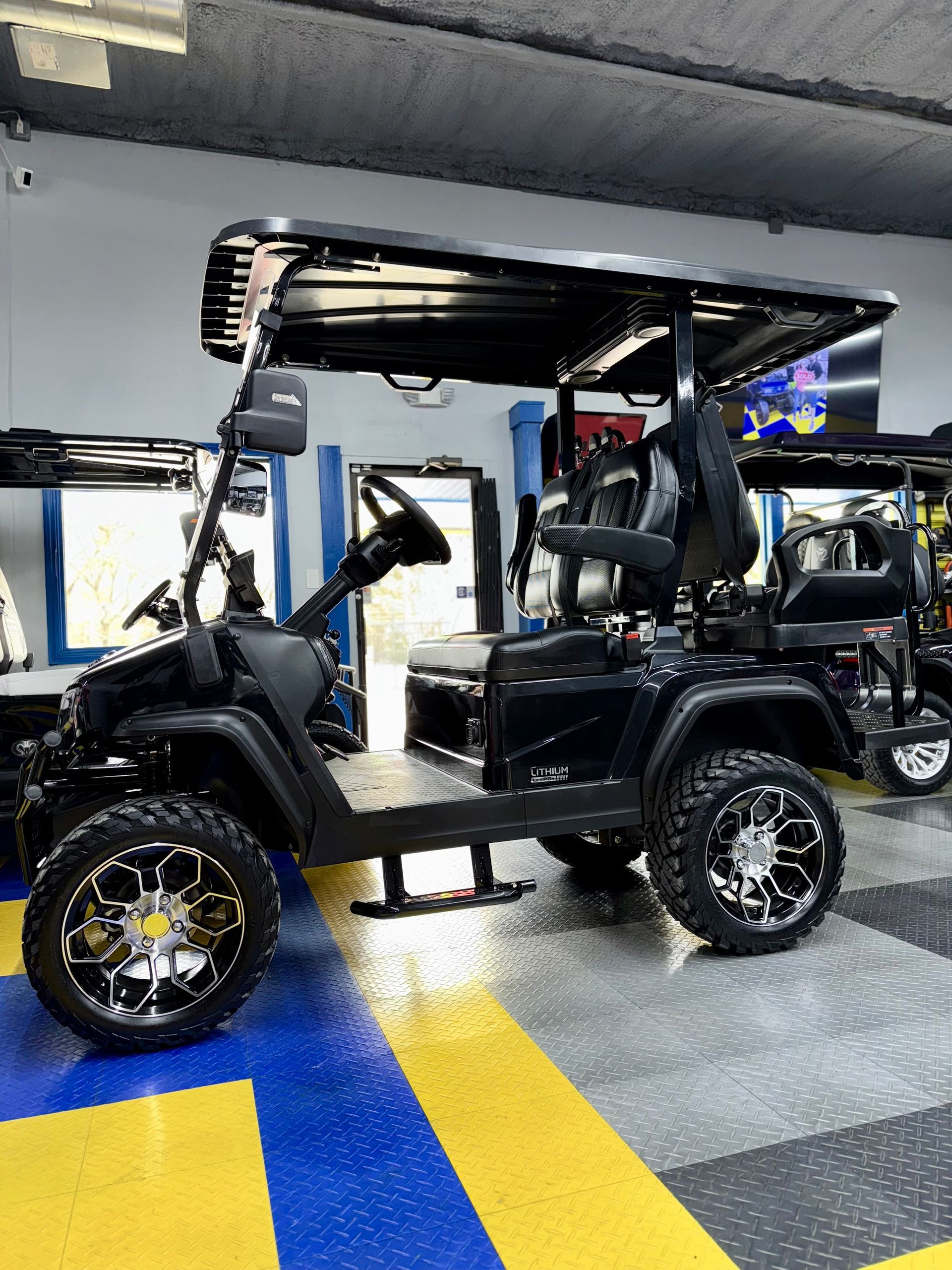 A black golf cart is parked in a garage.
