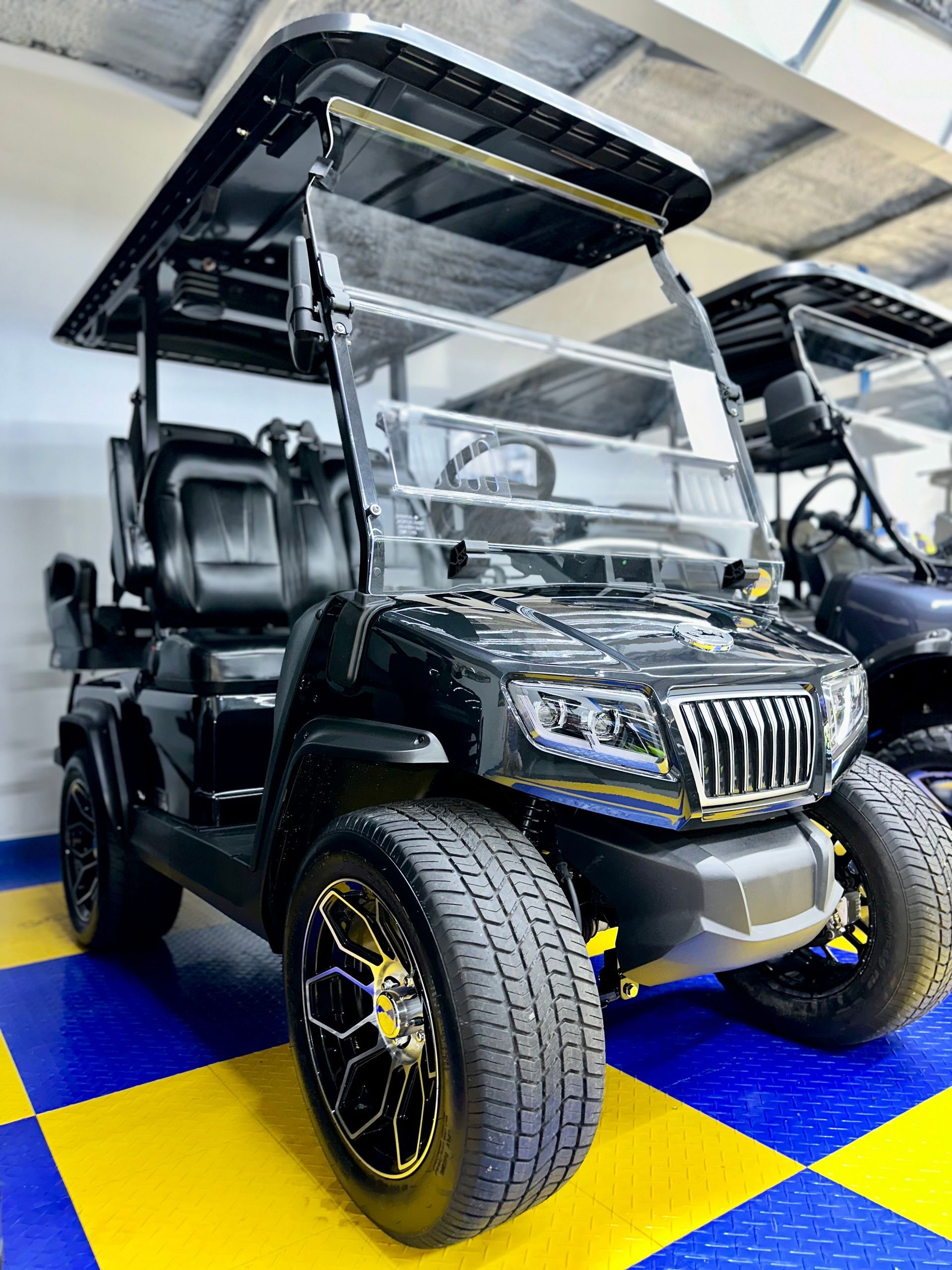 A black golf cart is parked in a showroom.