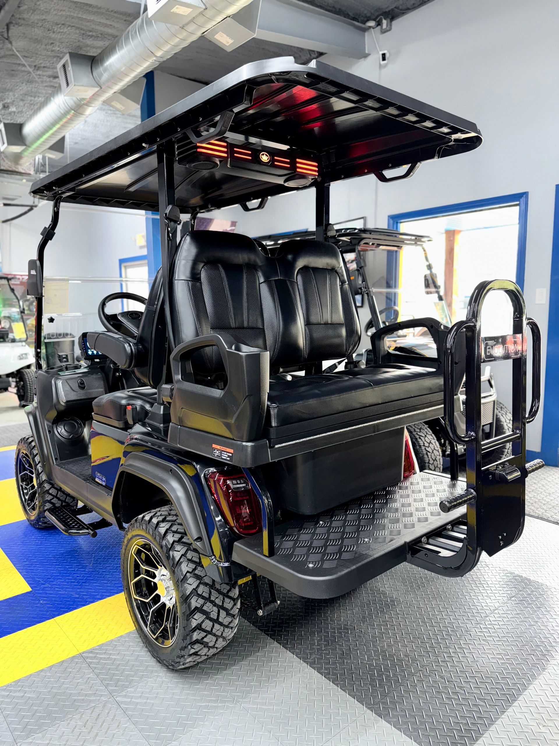 A black golf cart is parked in a garage.