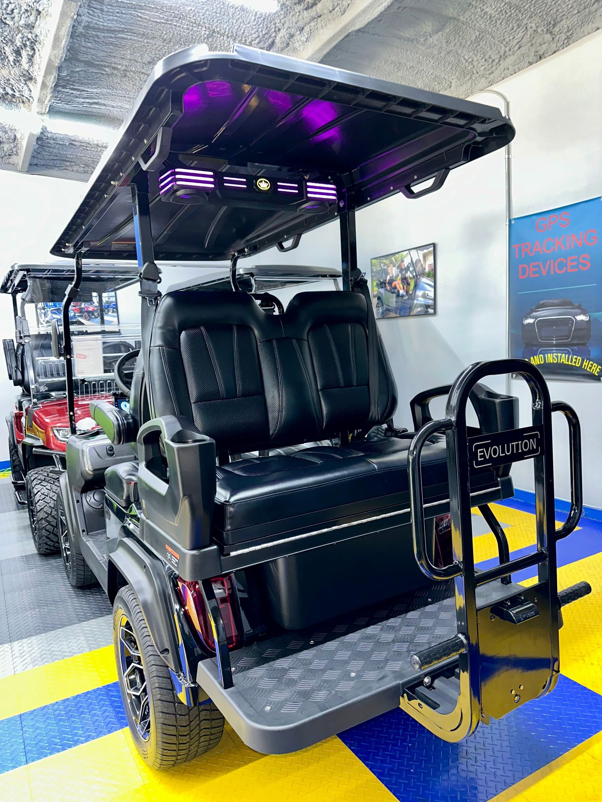 A golf cart is parked in a garage with other golf carts.