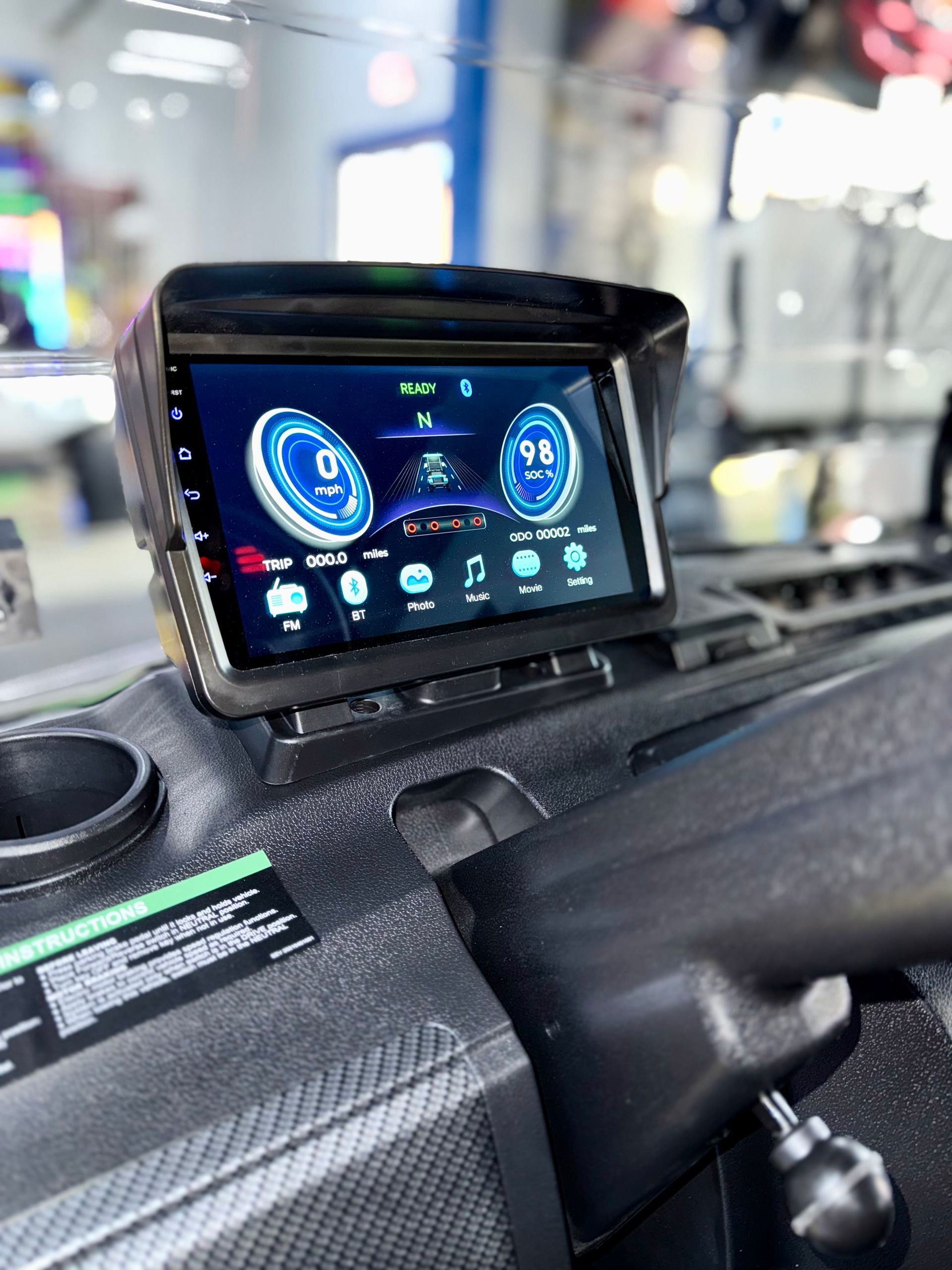 A car dashboard with a tablet sitting on top of it.