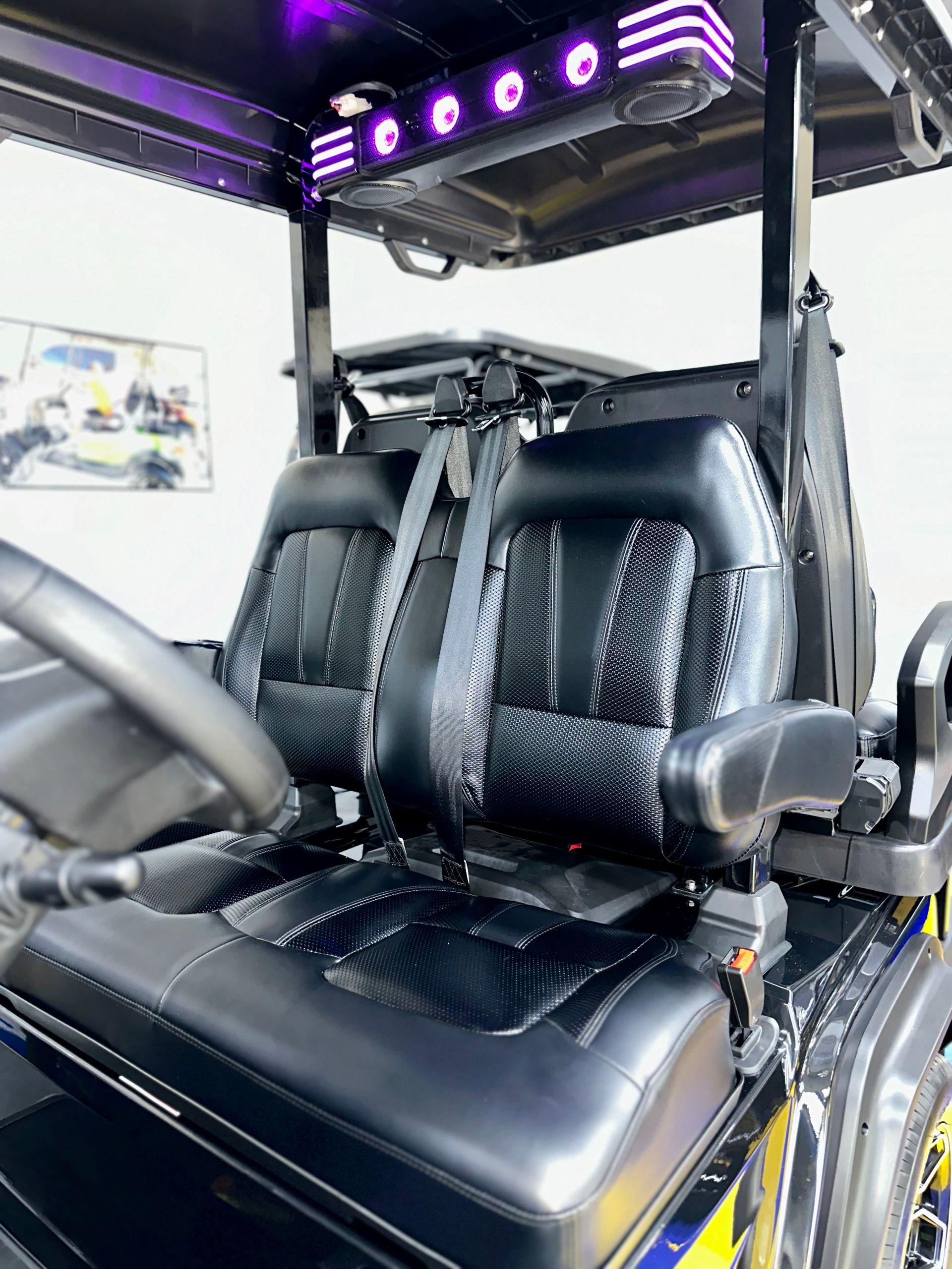 The inside of a golf cart with two seats and a steering wheel.
