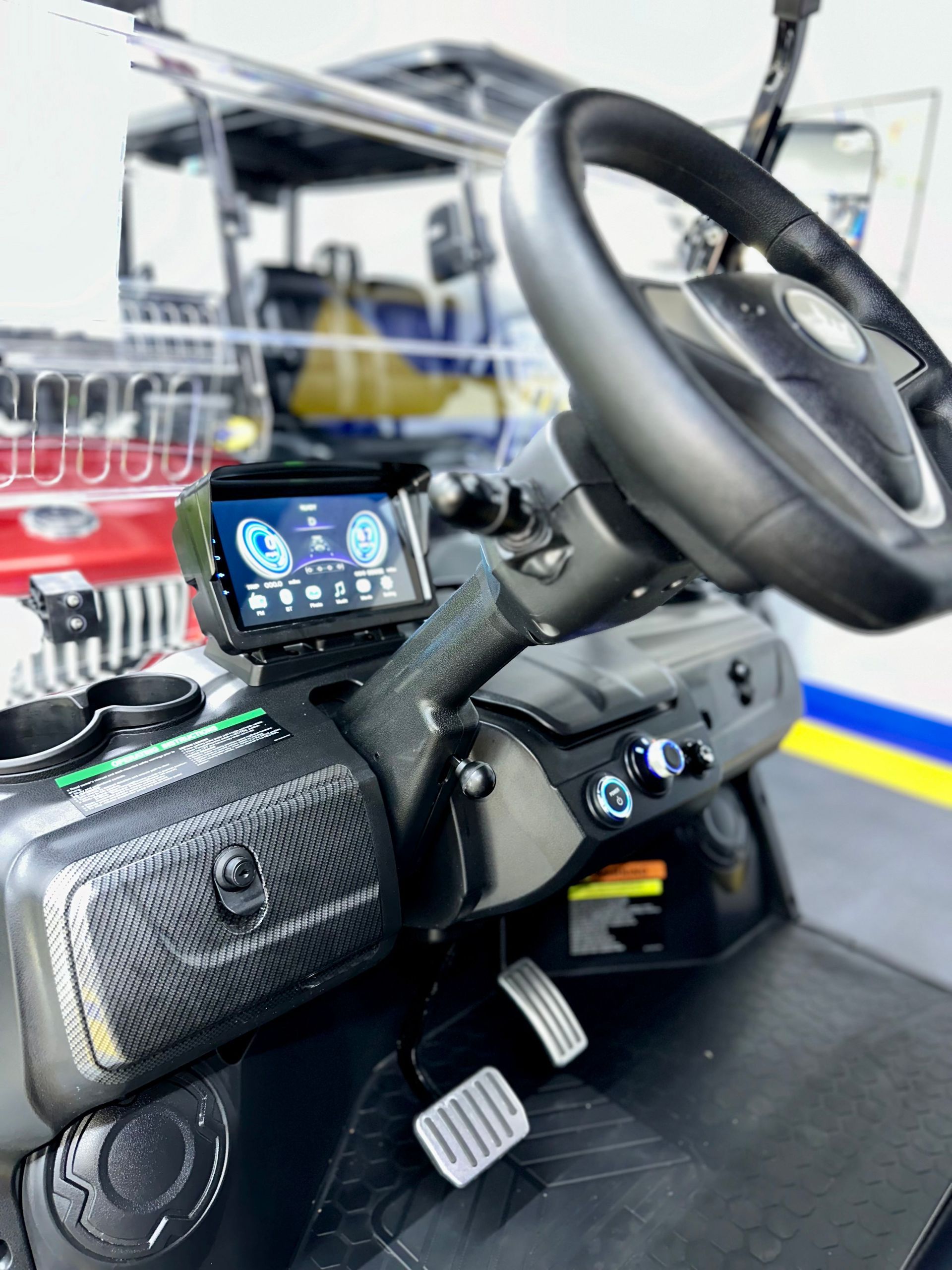 The inside of a golf cart with a steering wheel and dashboard.