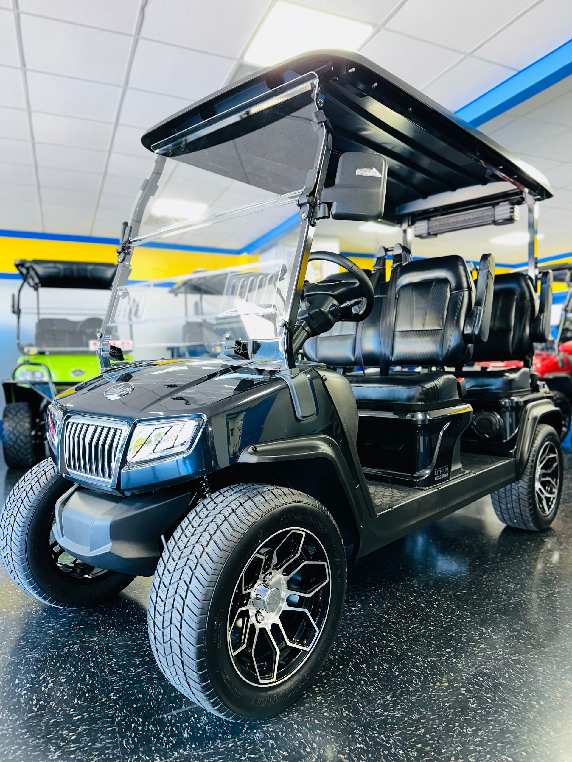 A black golf cart is parked in a showroom