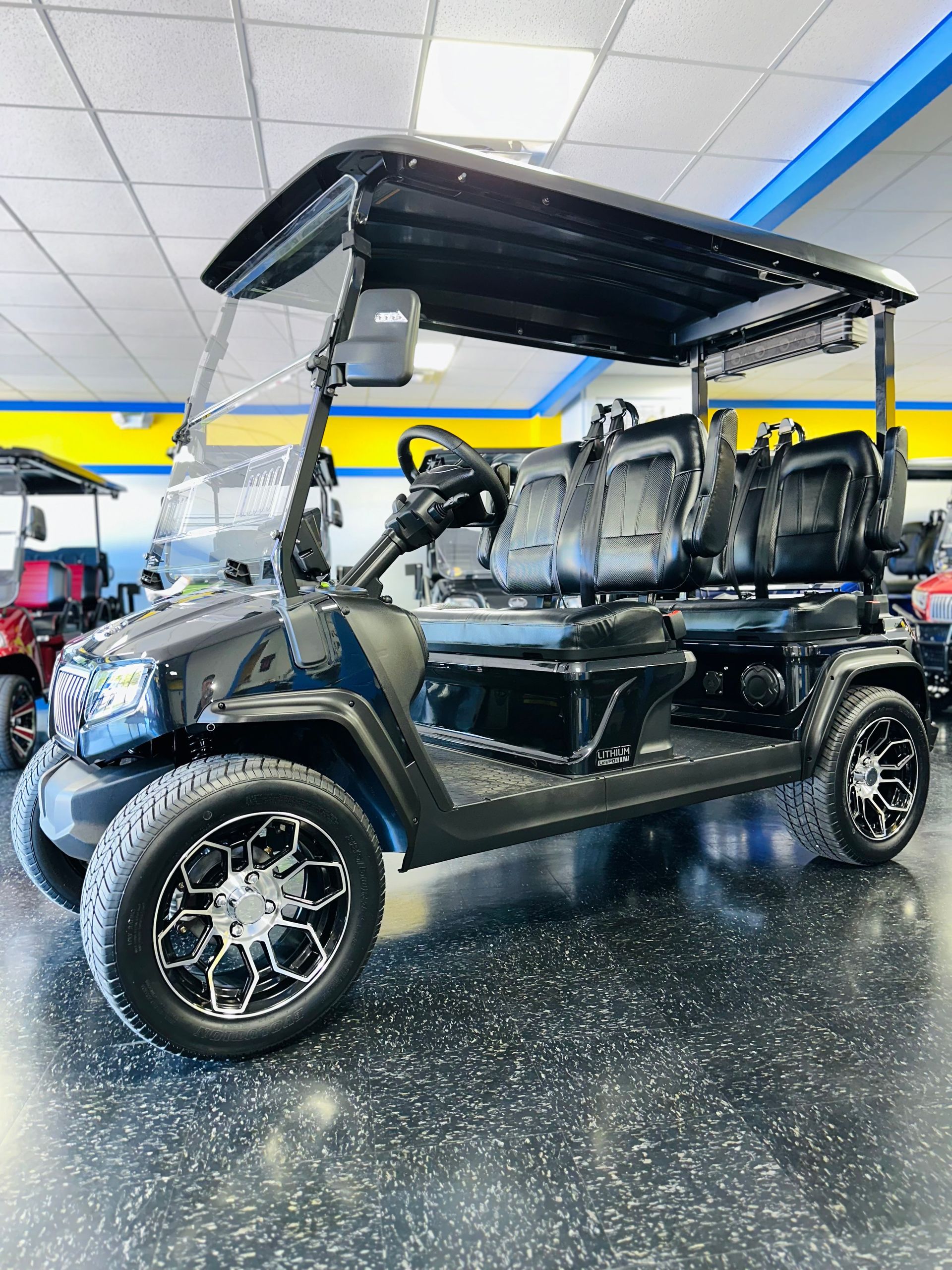 A black golf cart is parked in a showroom.
