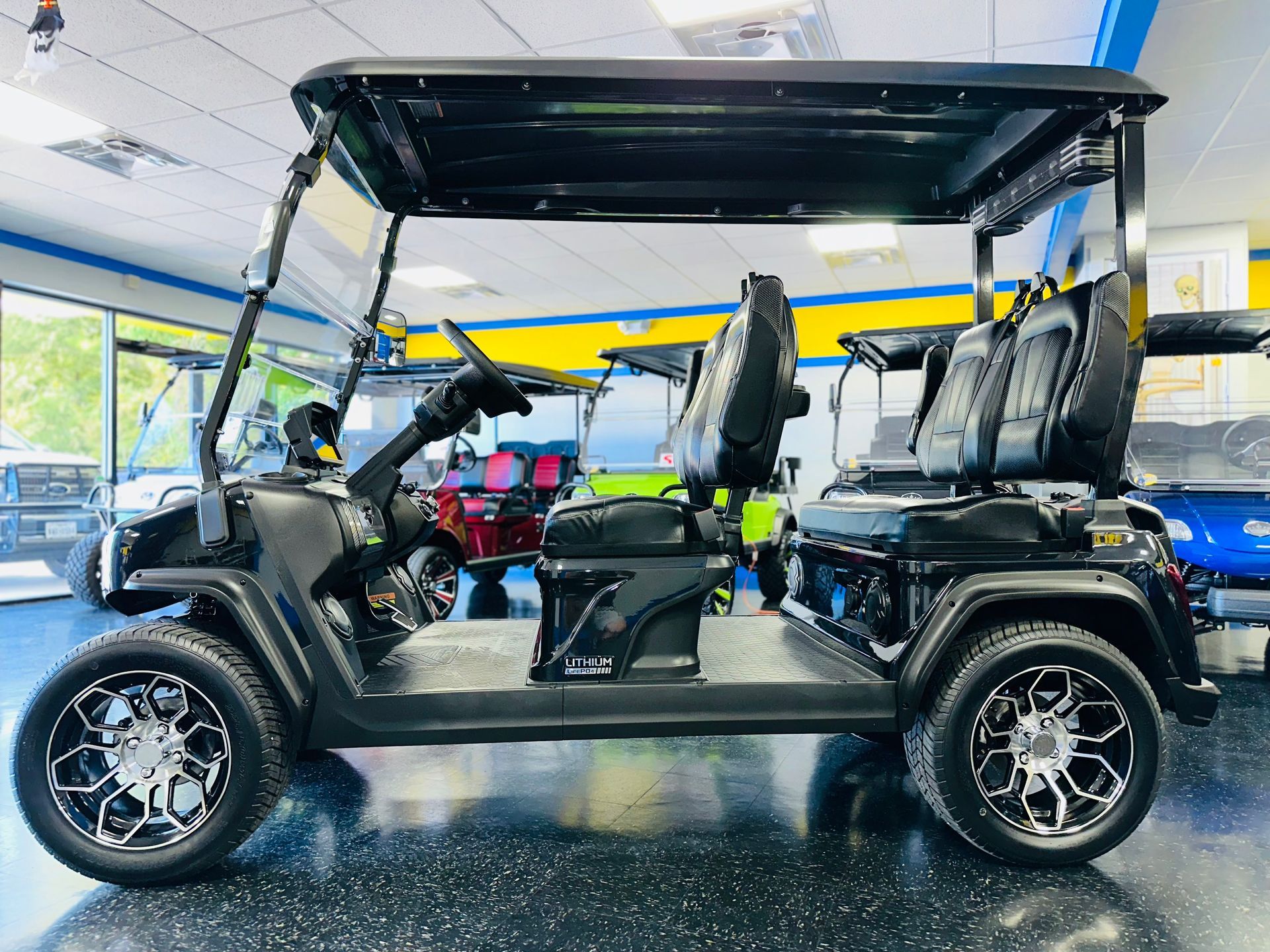A black golf cart is sitting in a showroom.