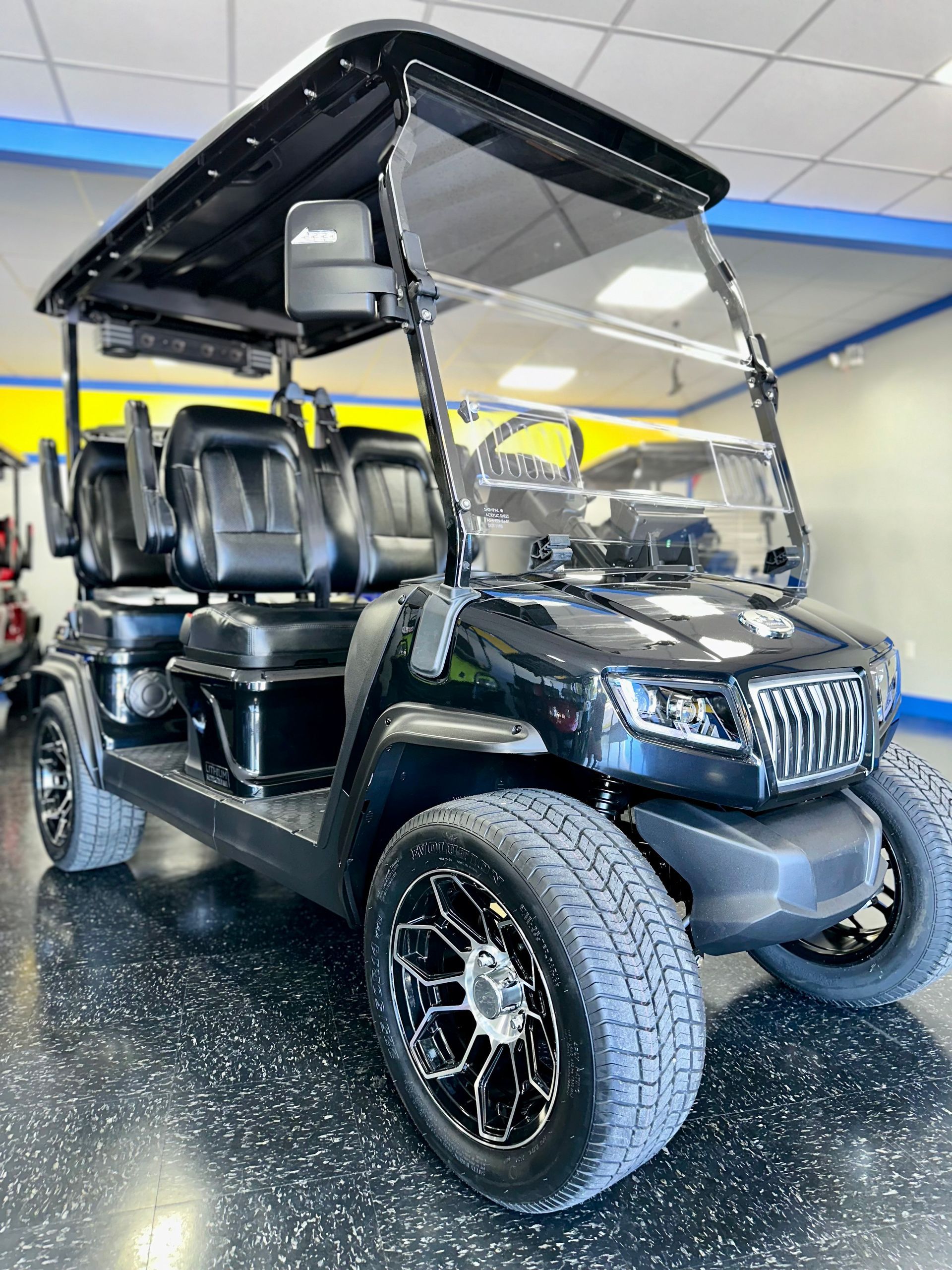 A black golf cart is parked in a showroom.