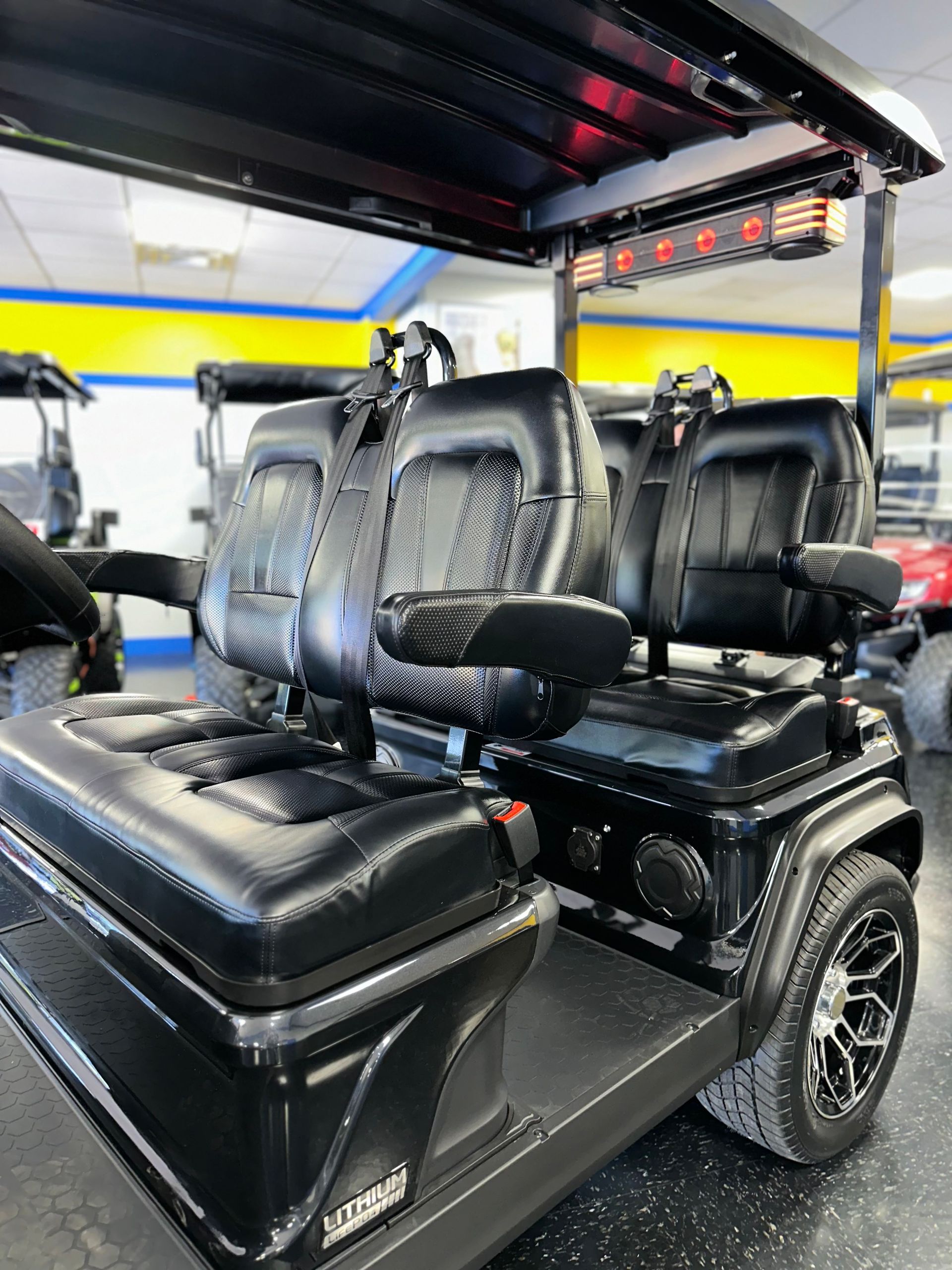 A black golf cart is parked in a garage.