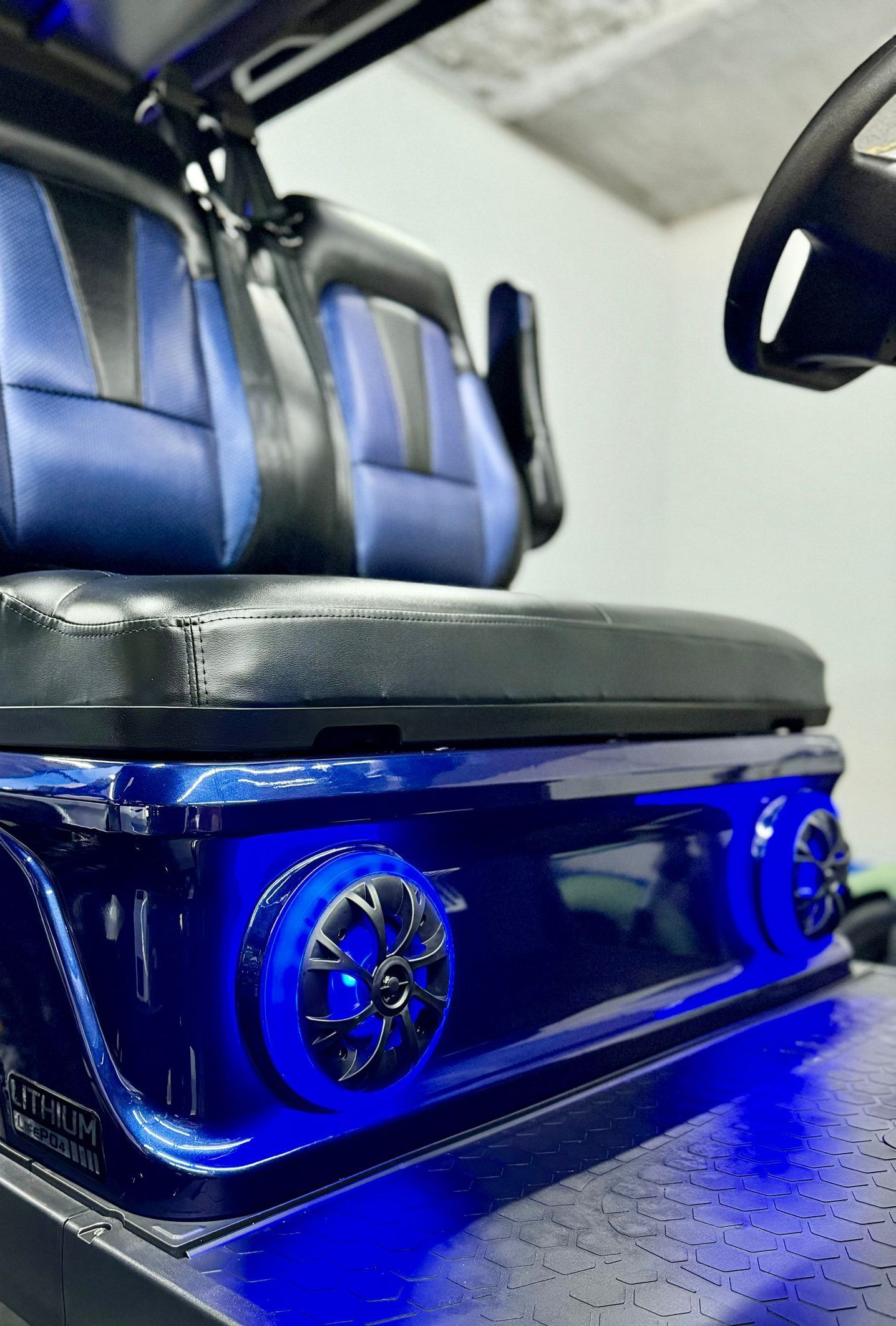 A golf cart with blue lights on the seat and steering wheel.